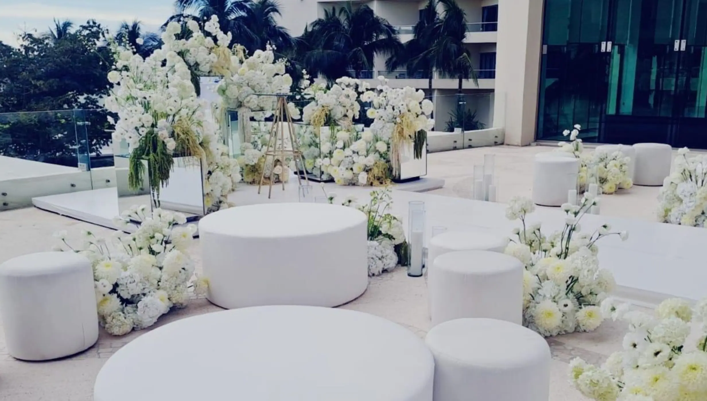 White floral arrangements and ottoman seating for a wedding reception at Live Aqua Beach Resort, Cancun