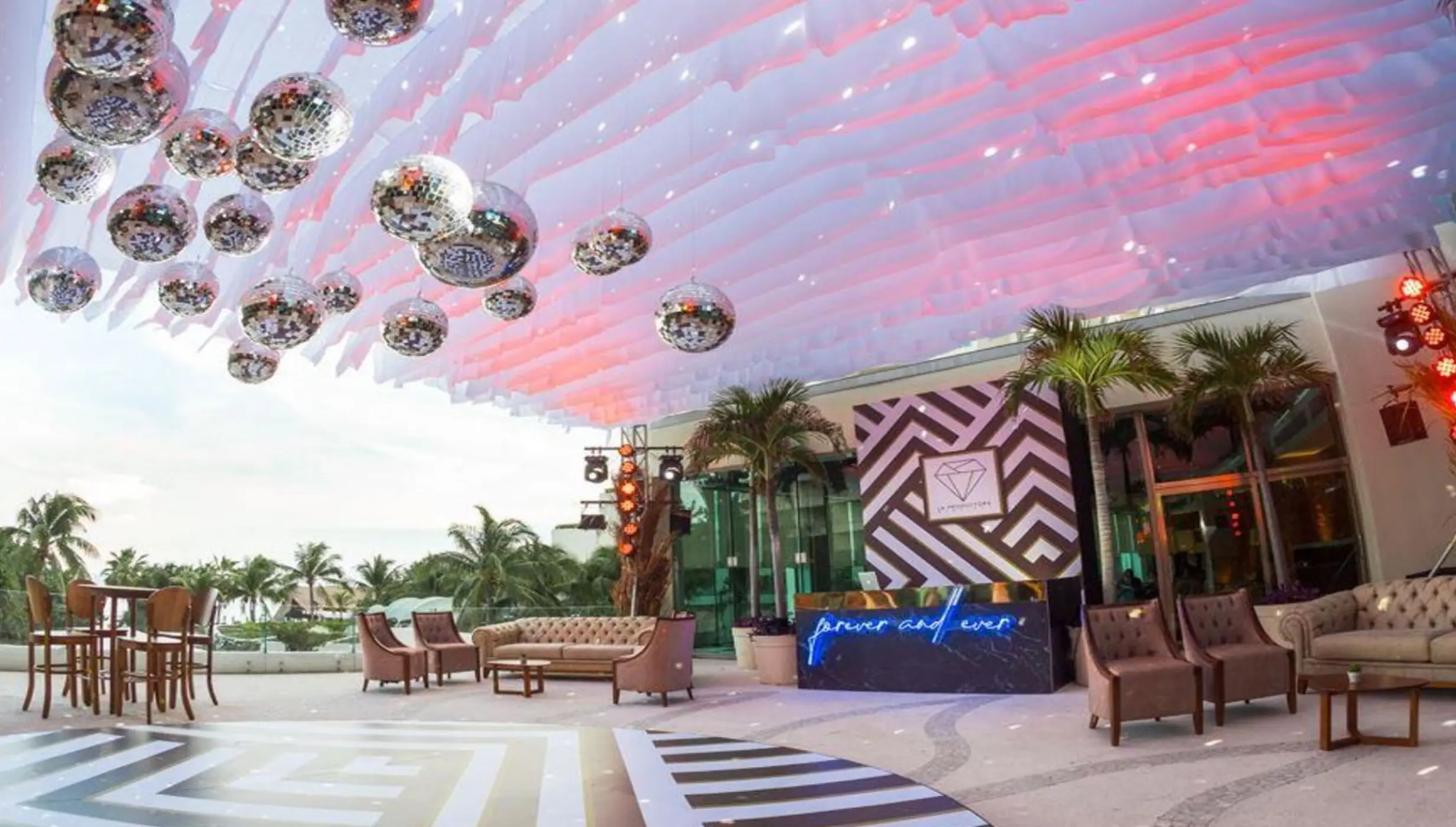 Wedding reception lounge on Egos Terrace at Live Aqua Cancun, featuring disco balls and a patterned dance floor