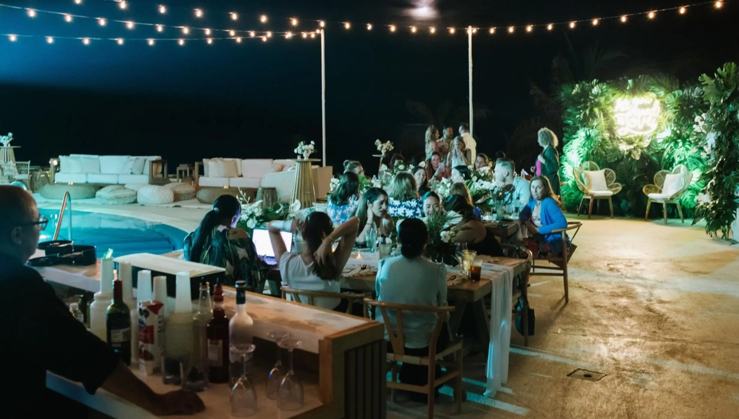 Evening wedding reception under string lights by the pool at Live Aqua Cancun