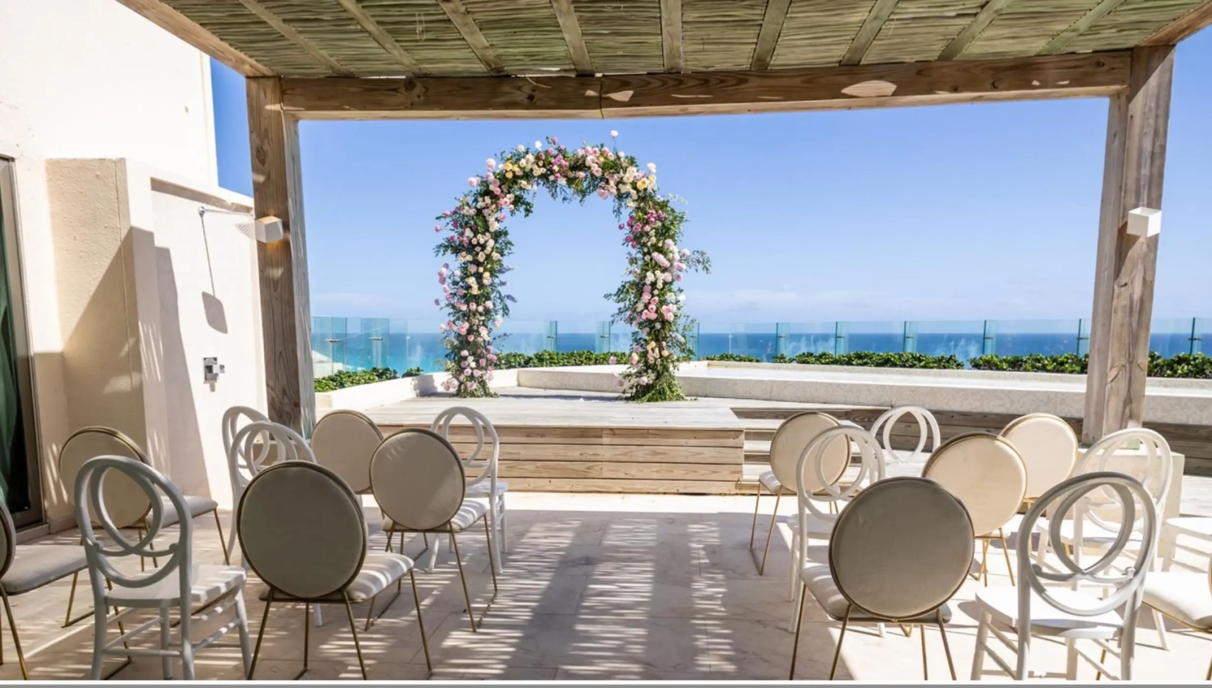 Terrace wedding ceremony with floral arch and ocean views at Live Aqua Cancun, Cancun