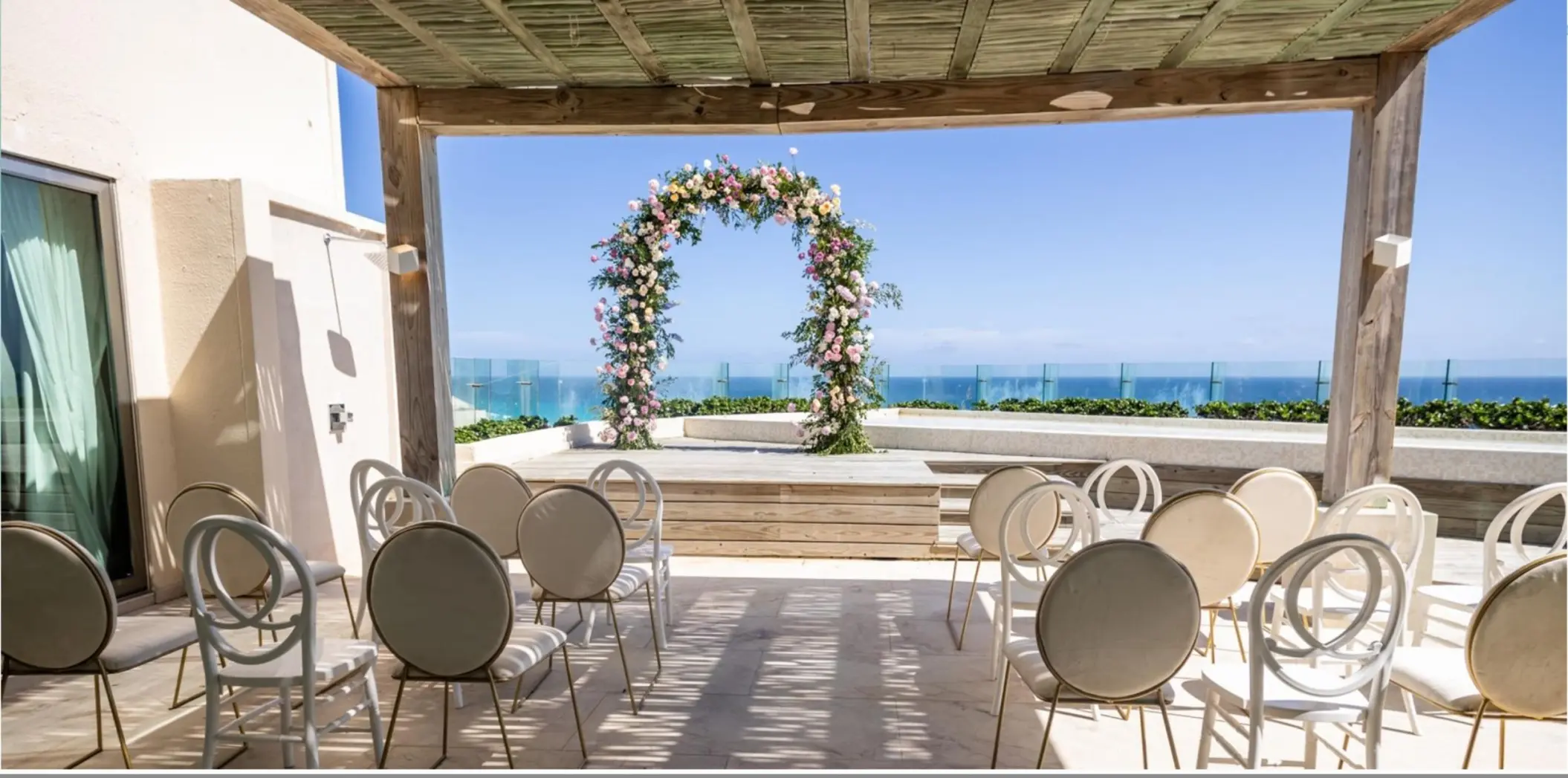 Terrace wedding ceremony with floral arch and ocean views at Live Aqua Cancun, Cancun