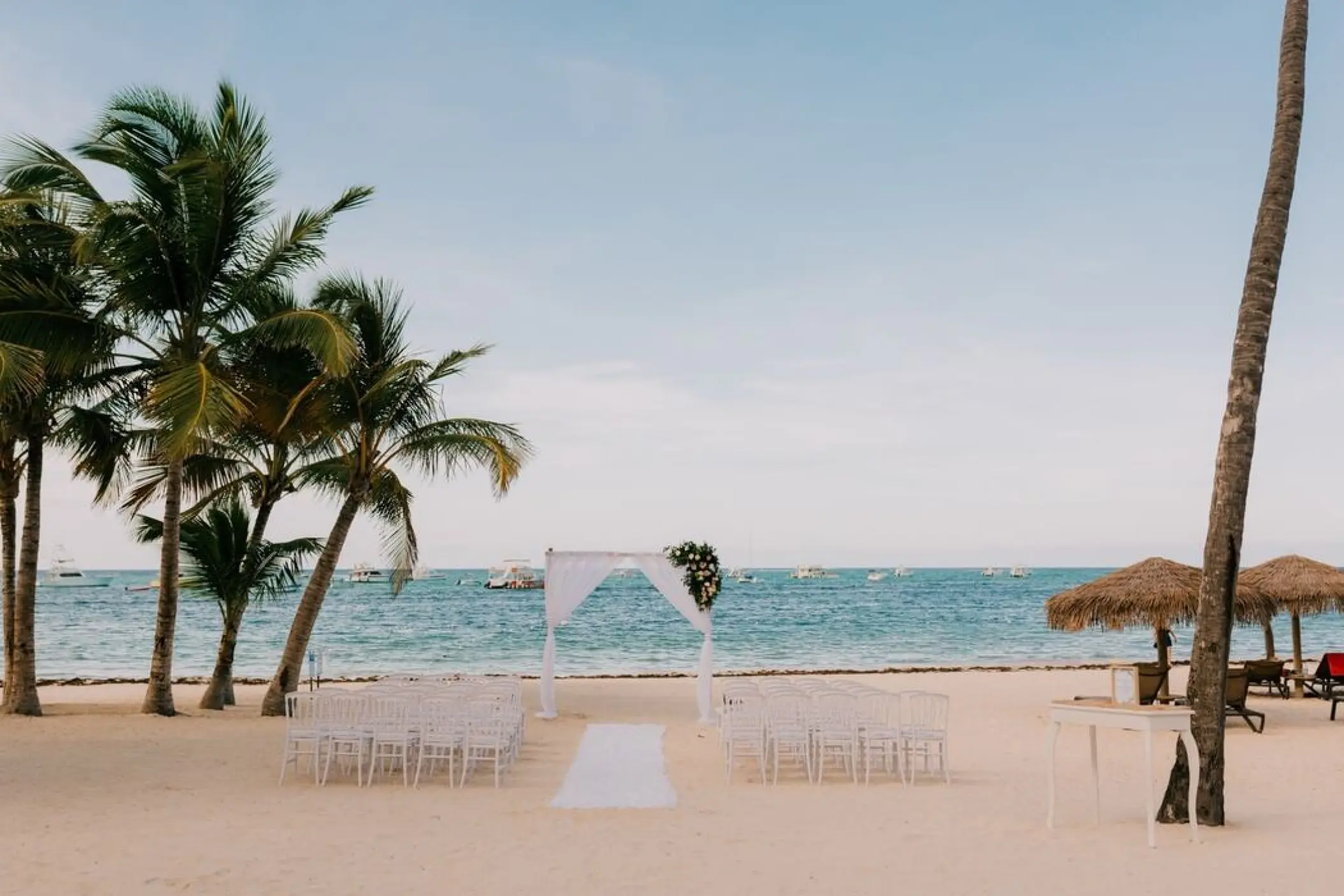Beachfront wedding ceremony with a white fabric arch at Lopesan Costa Bavaro, Punta Cana