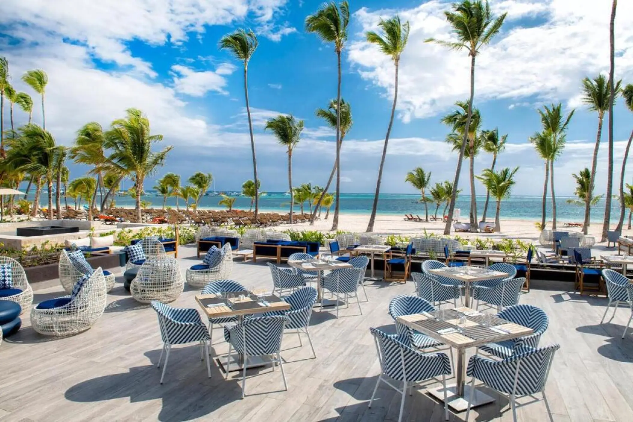 Beachside restaurant terrace with blue and white seating at Lopesan Costa Bavaro, Punta Cana