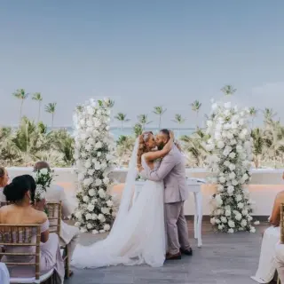 Rooftop wedding ceremony for a couple between white floral pillars at Lopesan Costa Bavaro, Punta Cana