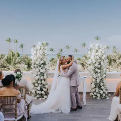 Rooftop wedding ceremony for a couple between white floral pillars at Lopesan Costa Bavaro, Punta Cana