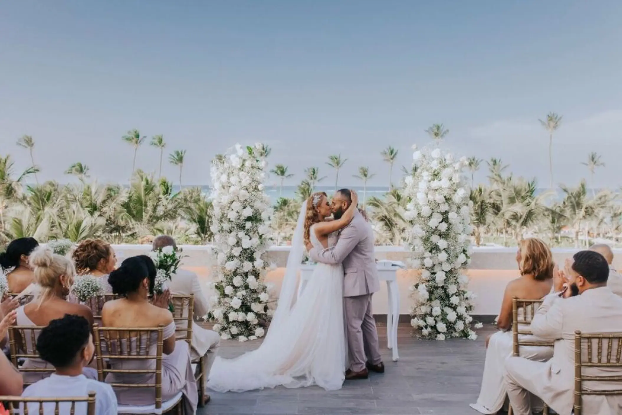 Rooftop wedding ceremony for a couple between white floral pillars at Lopesan Costa Bavaro, Punta Cana