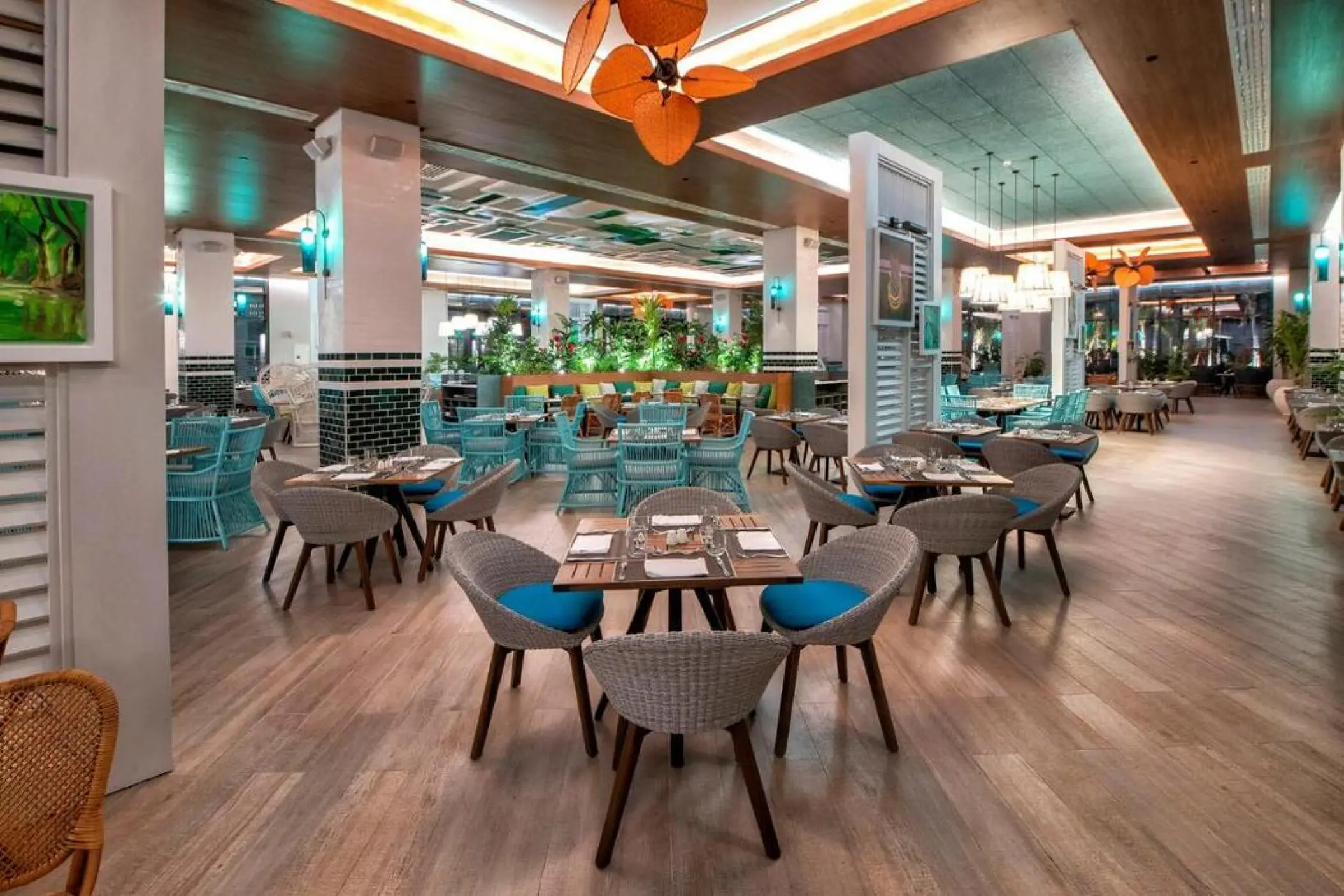 Modern indoor restaurant with blue and grey wicker seating at Lopesan Costa Bavaro, Punta Cana