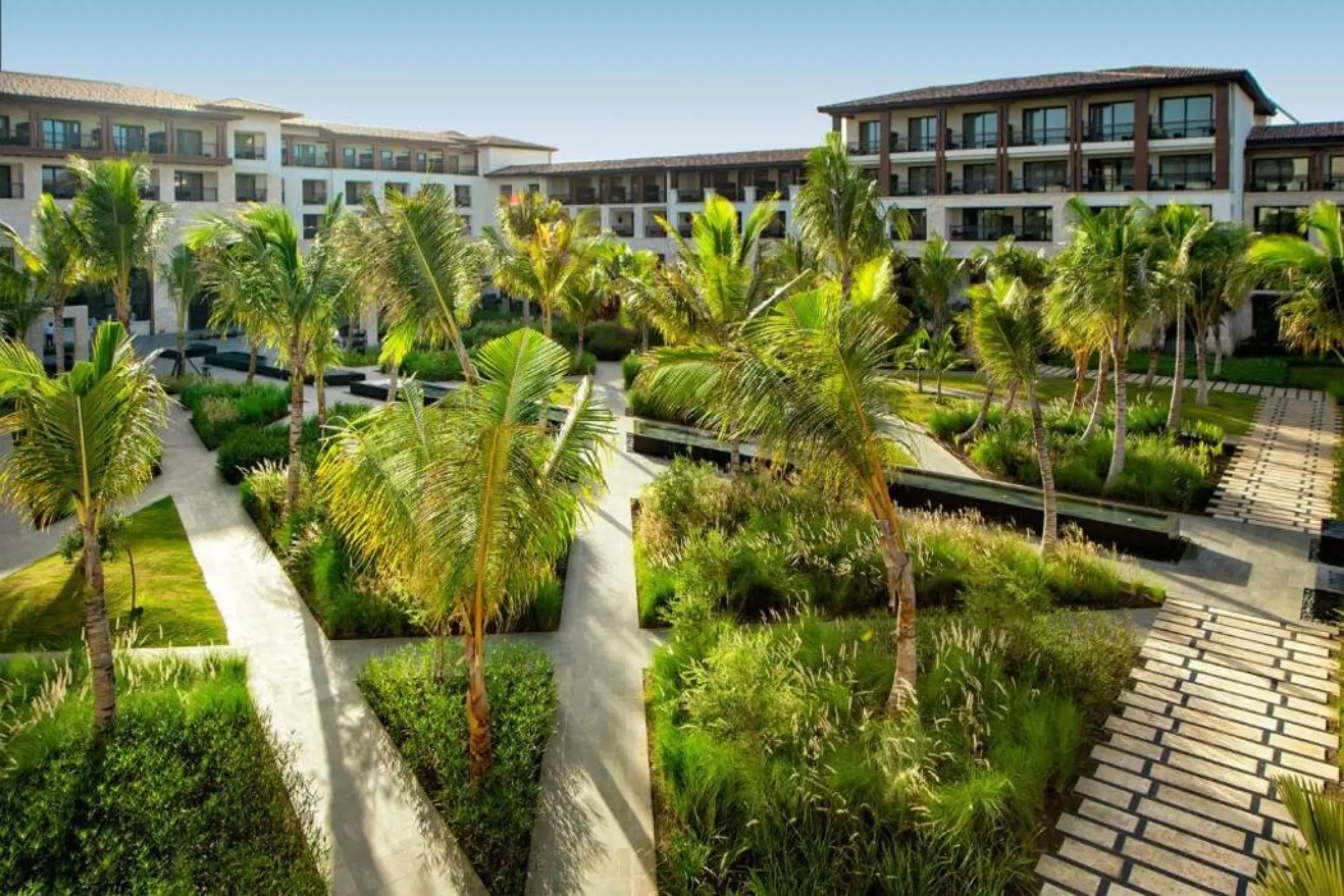 Landscaped garden pathways and guest room buildings at Lopesan Costa Bavaro, Punta Cana