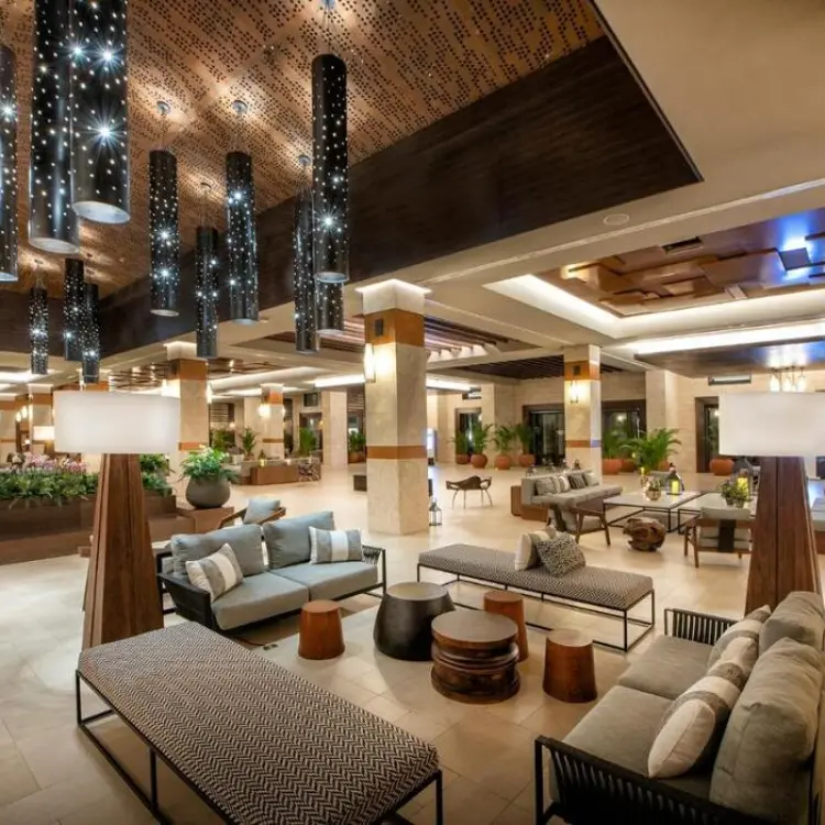 Modern lobby seating area with cylindrical pendant lights at Lopesan Costa Bavaro, Punta Cana