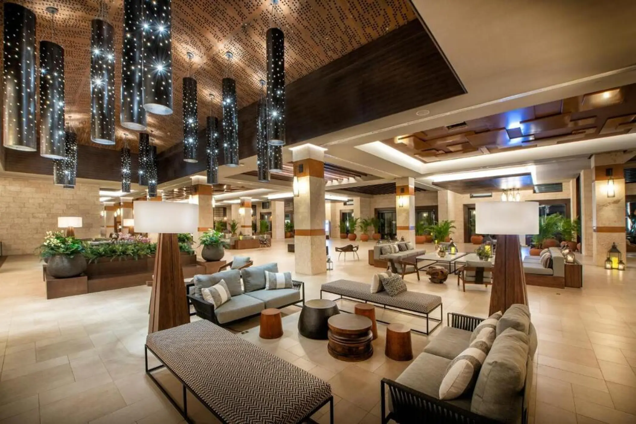 Modern lobby seating area with cylindrical pendant lights at Lopesan Costa Bavaro, Punta Cana
