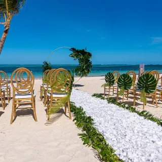 Beach wedding ceremony with gold chairs and white flower petal aisle at Lopesan Costa Bavaro, Punta Cana