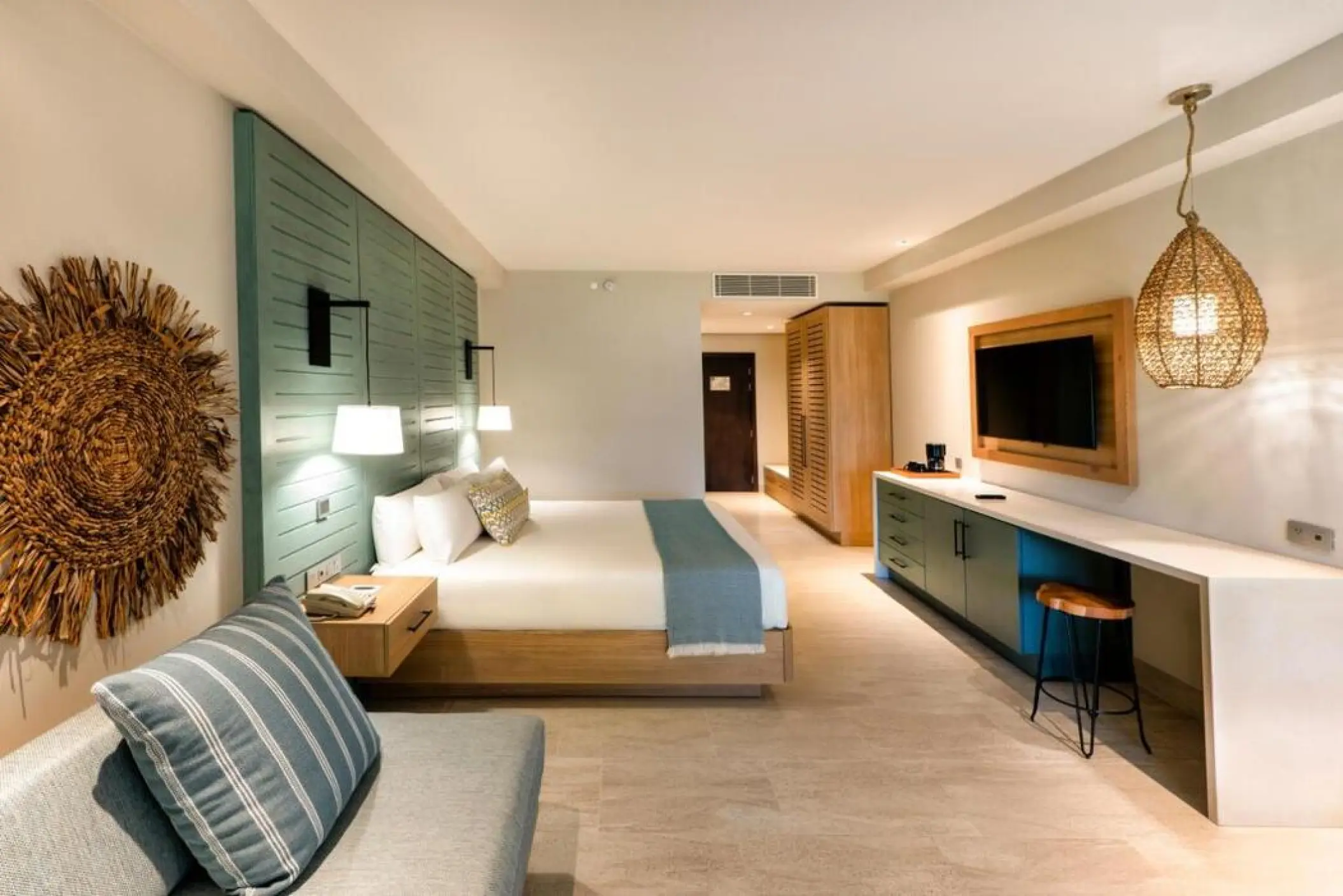 Tropical Junior Suite with king bed and teal accents at Lopesan Costa Bavaro, Punta Cana