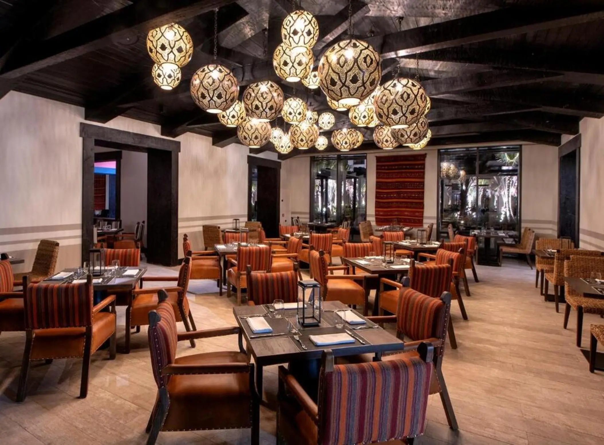 Indoor restaurant with spherical patterned pendant lights at Lopesan Costa Bavaro, Punta Cana