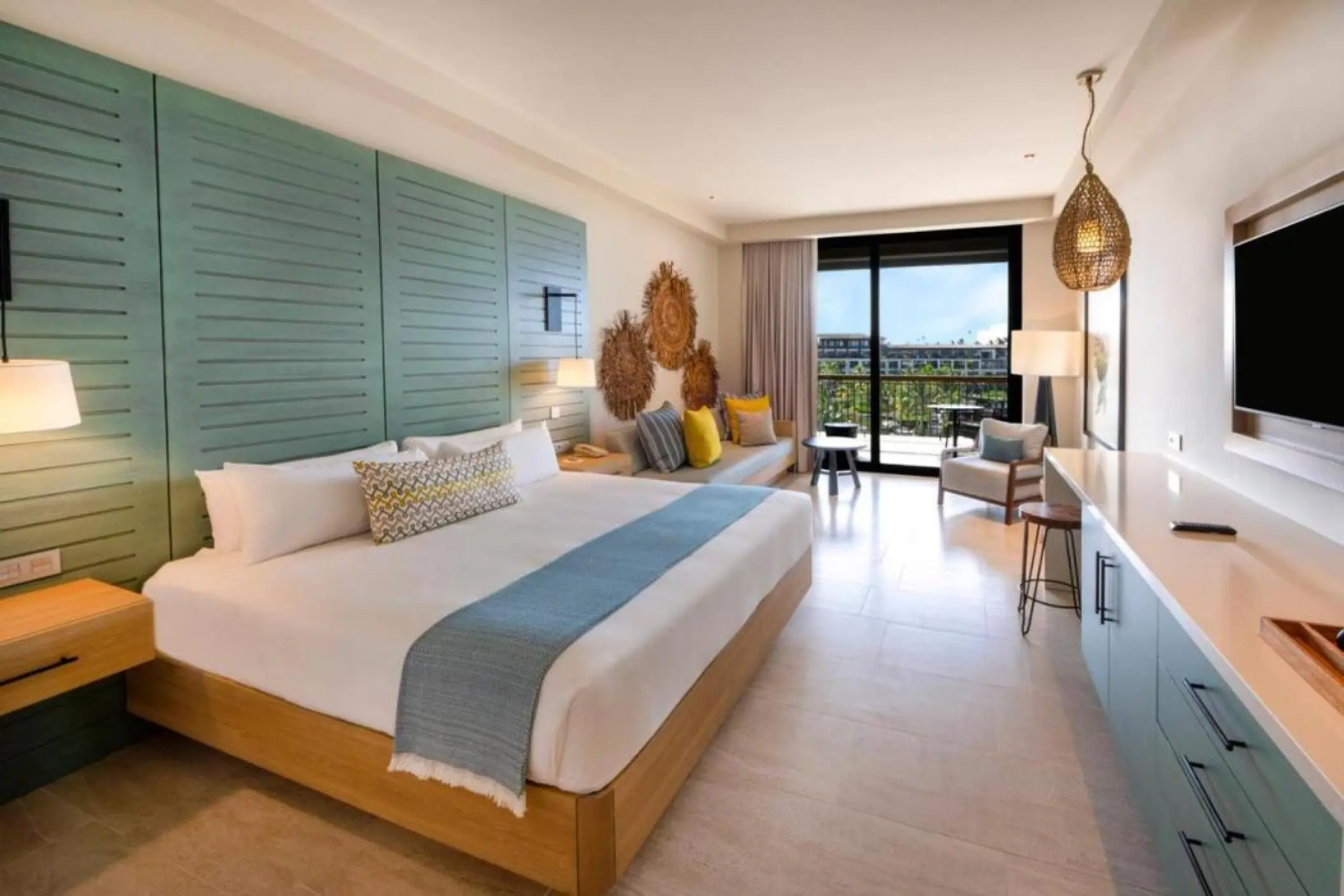 Modern suite with blue wood paneling and private balcony at Lopesan Costa Bavaro, Punta Cana