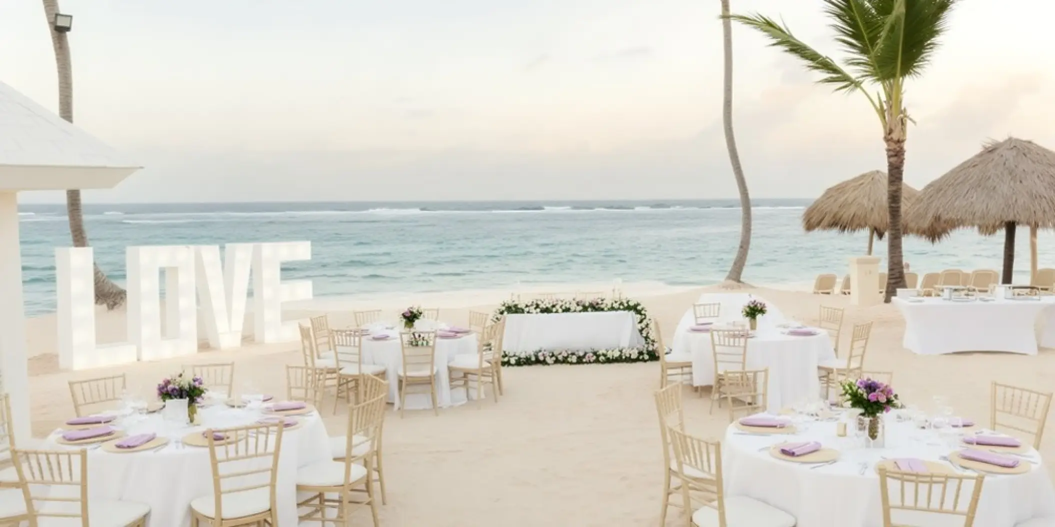 Beachfront wedding reception with LOVE letters and floral decor at Majestic Colonial, Punta Cana
