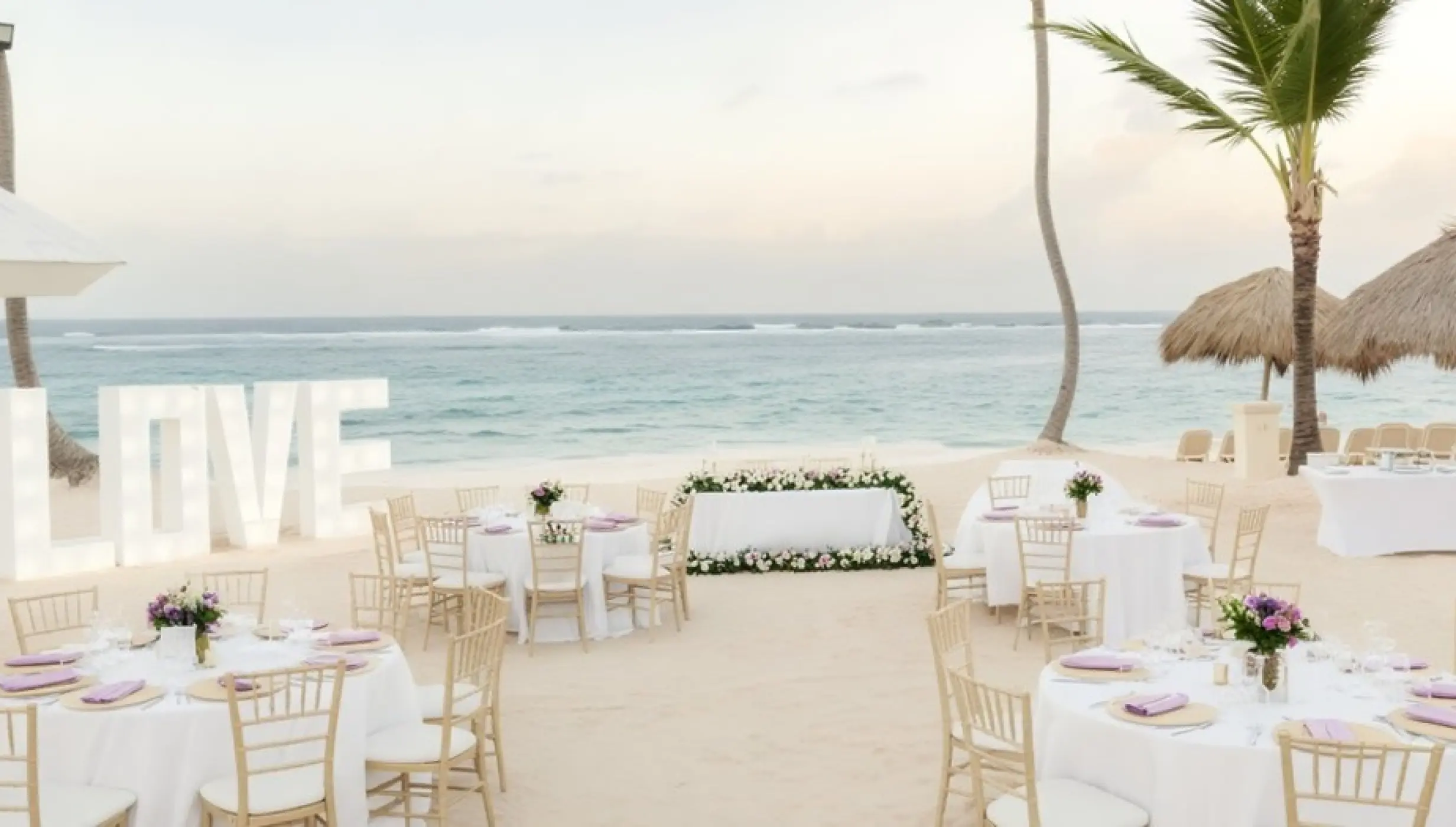 Beachfront wedding reception with LOVE letters and floral decor at Majestic Colonial, Punta Cana