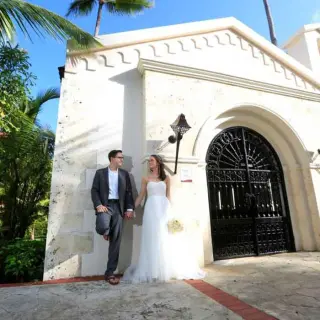 Bride and groom posing by the stone chapel at Majestic Colonial, Punta Cana
