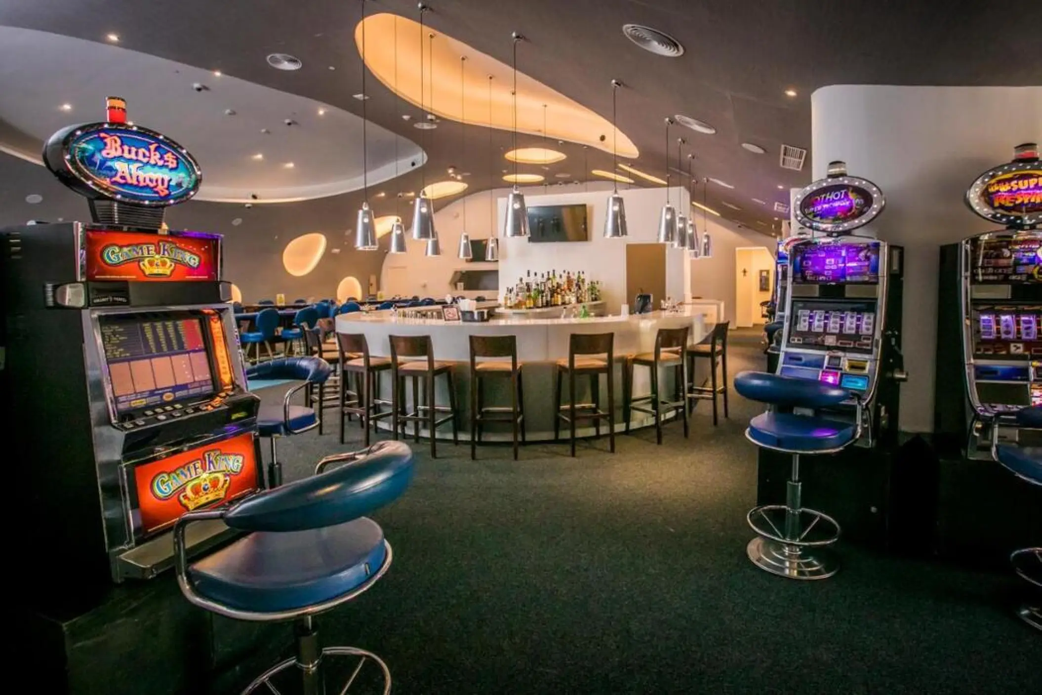 Casino slot machines and circular bar with wooden stools at Majestic Colonial, Punta Cana