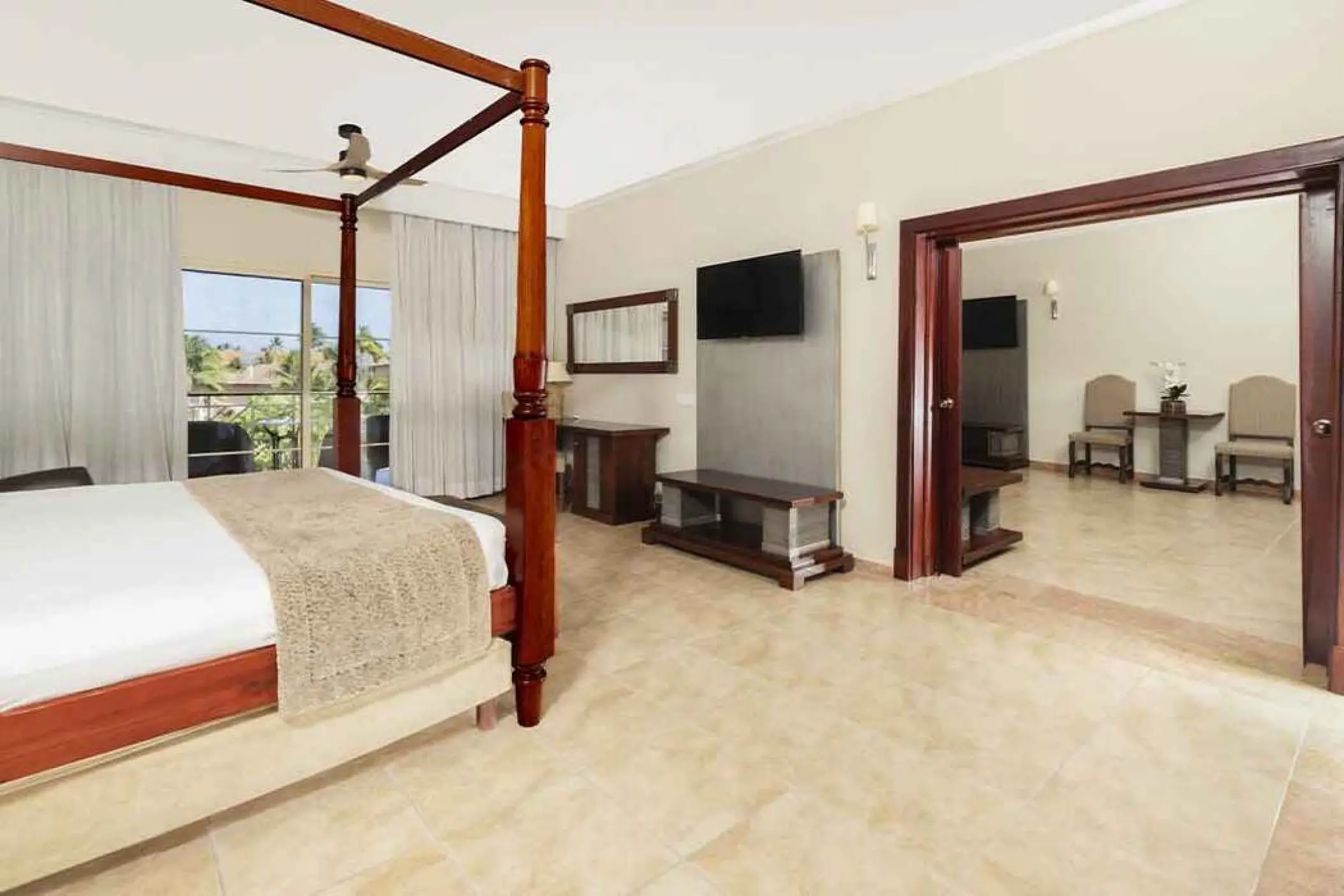 Four-poster bed and sitting area in a suite at Majestic Colonial, Punta Cana