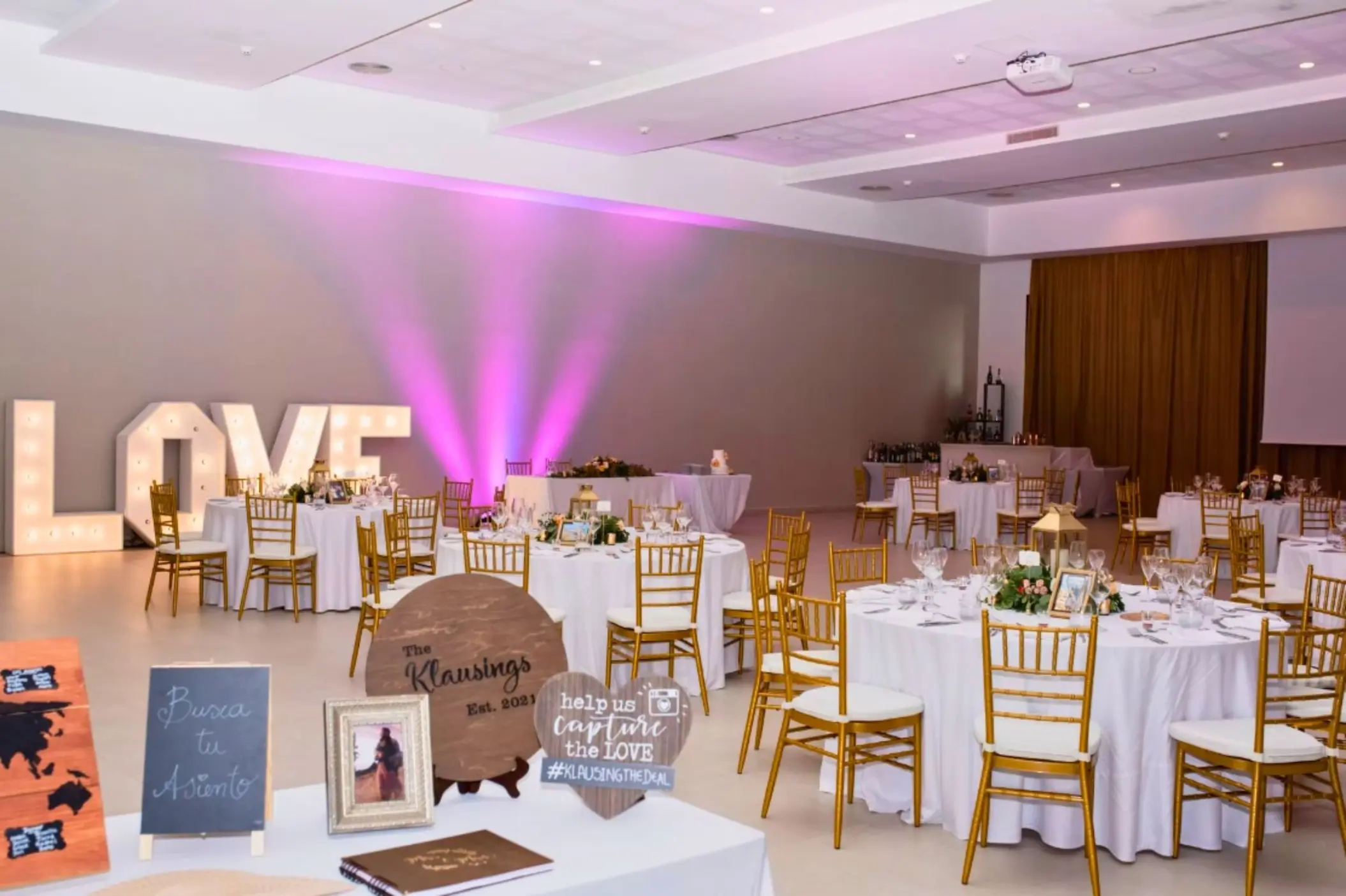 Indoor wedding reception with pink uplighting and large marquee LOVE letters at Majestic Mirage, Cancun