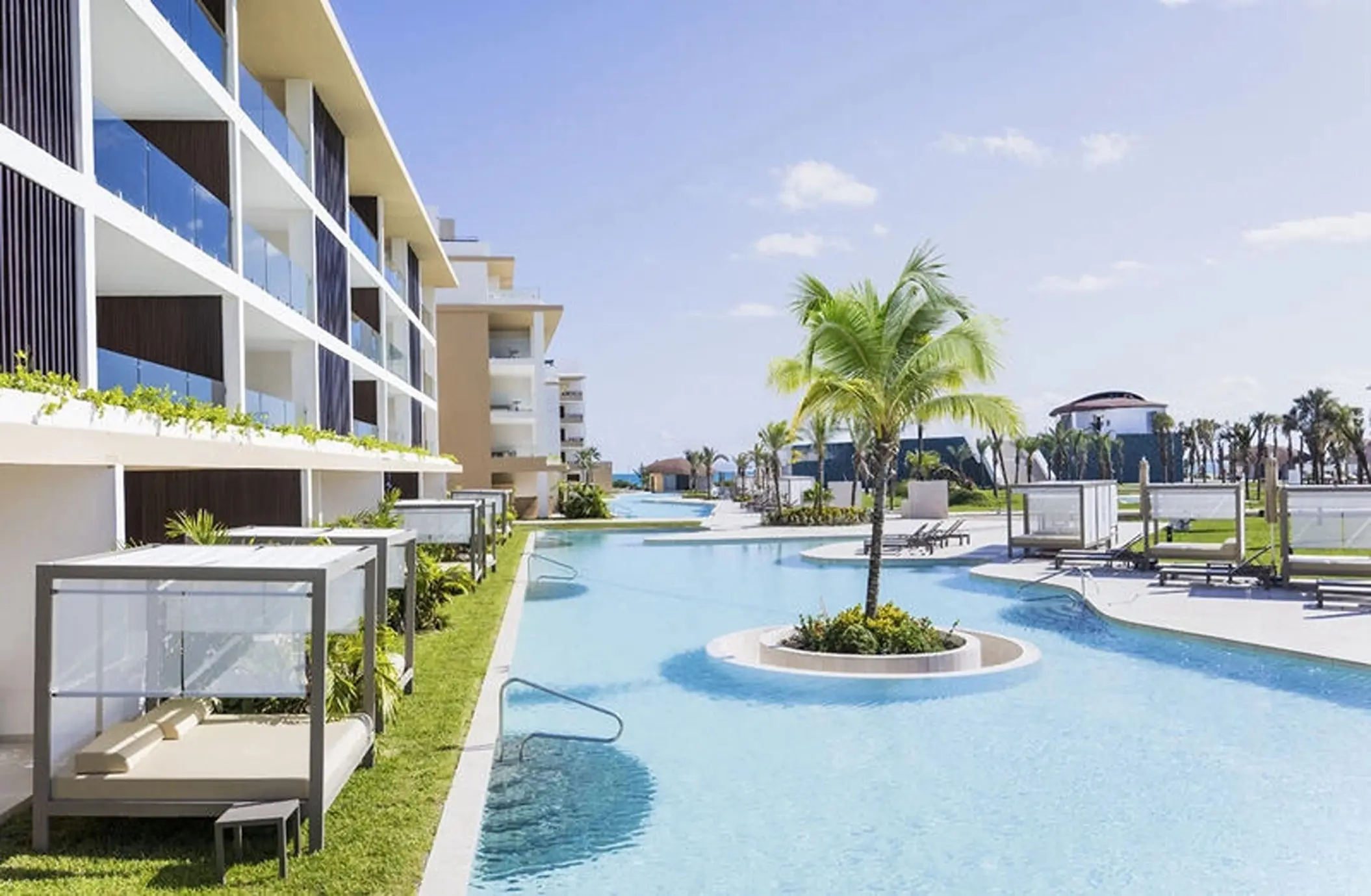 Swim-out suite exterior and winding pool with cabanas at Majestic Mirage Costa Mujeres, Cancun