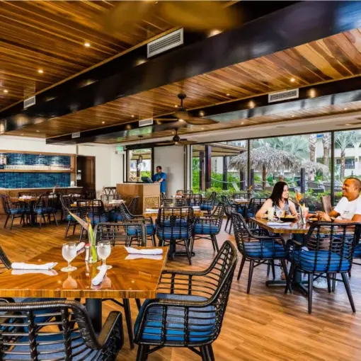 Banana Wind Cafe dining area with wooden ceilings and blue accents at Margaritaville Playa Flamingo, Liberia