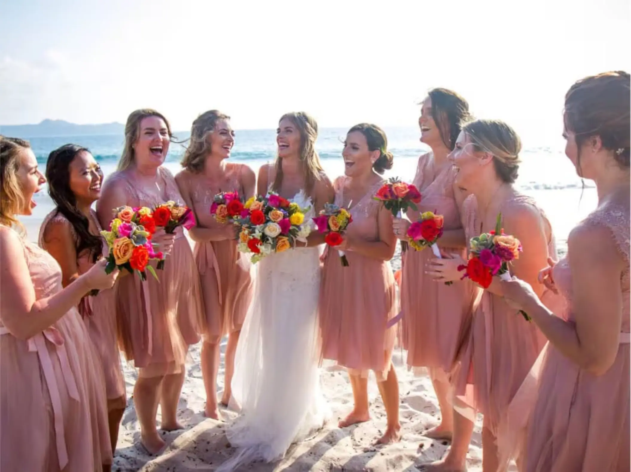 Bride and bridesmaids laughing on the beach at Margaritaville Playa Flamingo, Liberia
