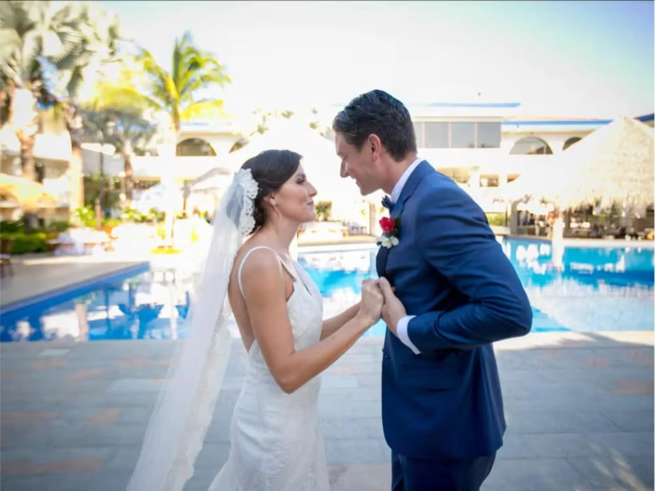 Bride and groom holding hands by the pool at Margaritaville Beach Resort Playa Flamingo, Liberia