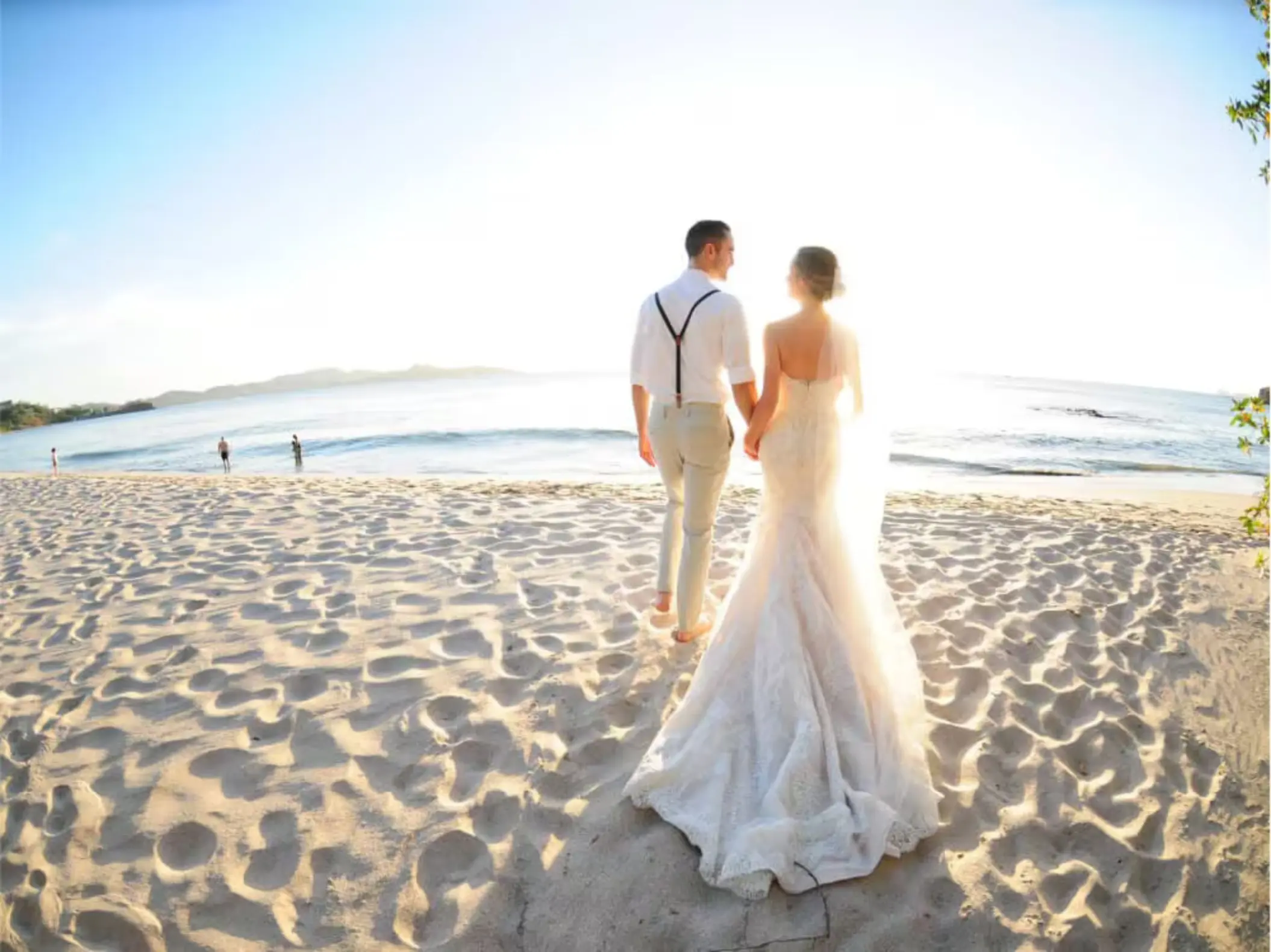 Bride and groom walking on the sand at Margaritaville Beach Resort Playa Flamingo, Liberia