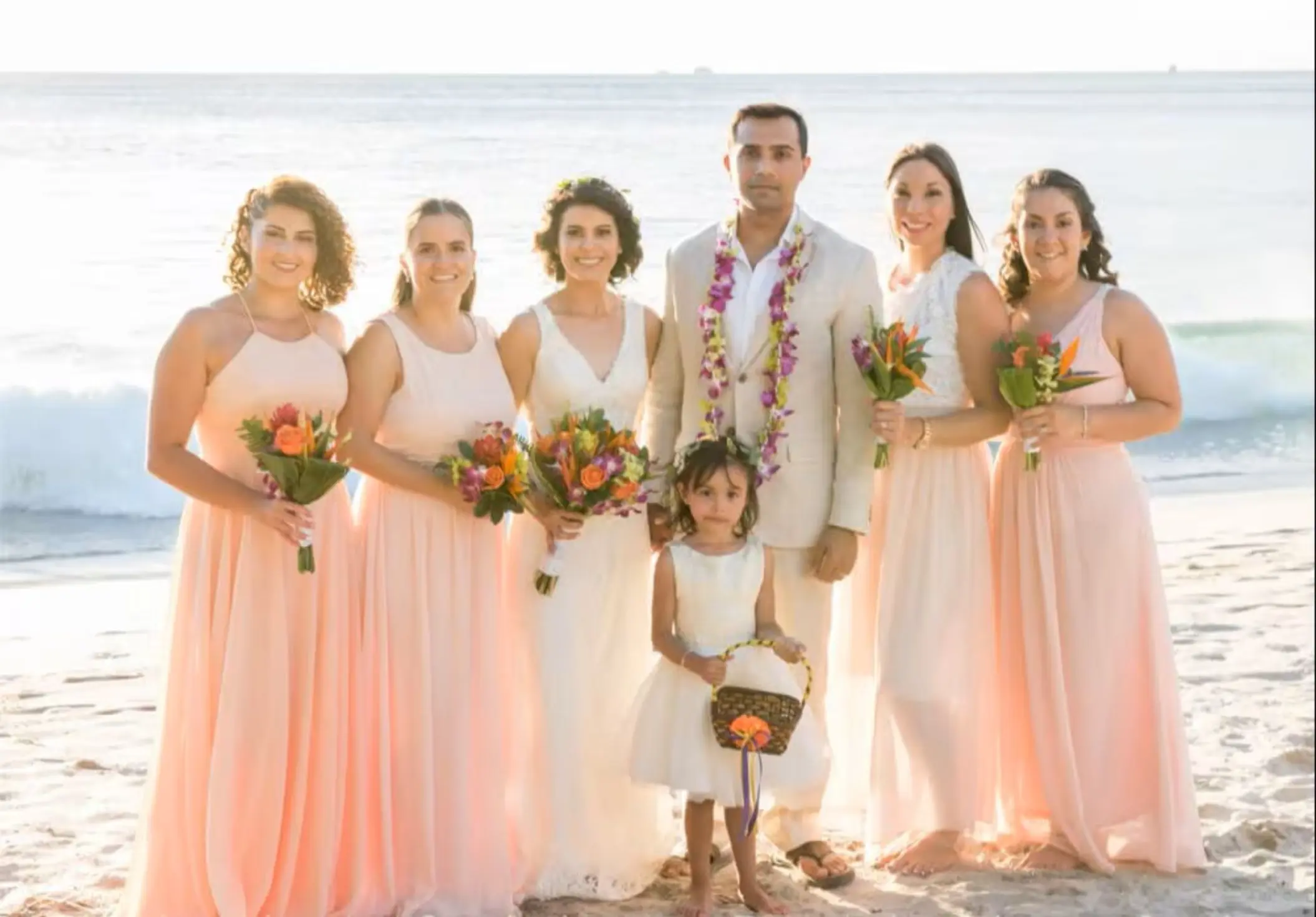 The couple with their bridesmaids and flower girl on the beach at Margaritaville Playa Flamingo, Liberia