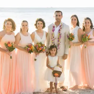 The couple with their bridesmaids and flower girl on the beach at Margaritaville Playa Flamingo, Liberia