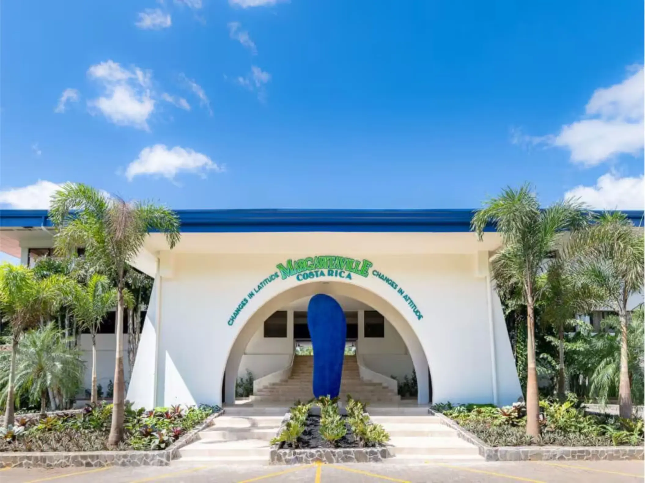 Main entrance of Margaritaville Beach Resort Playa Flamingo featuring a large blue flip-flop sculpture, Liberia