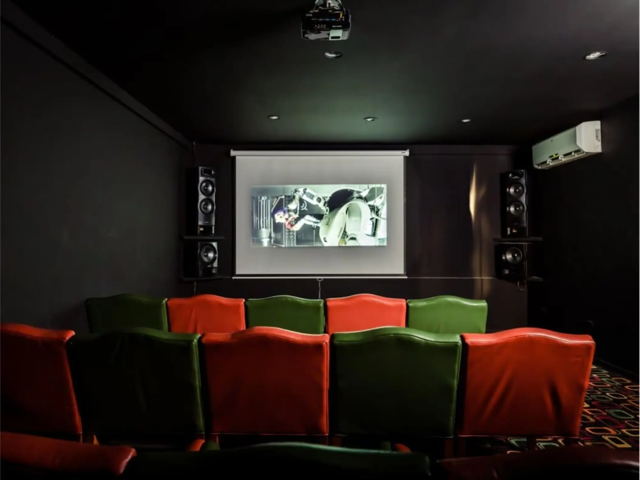 Private movie theater with red and green seating at Margaritaville Playa Flamingo, Liberia