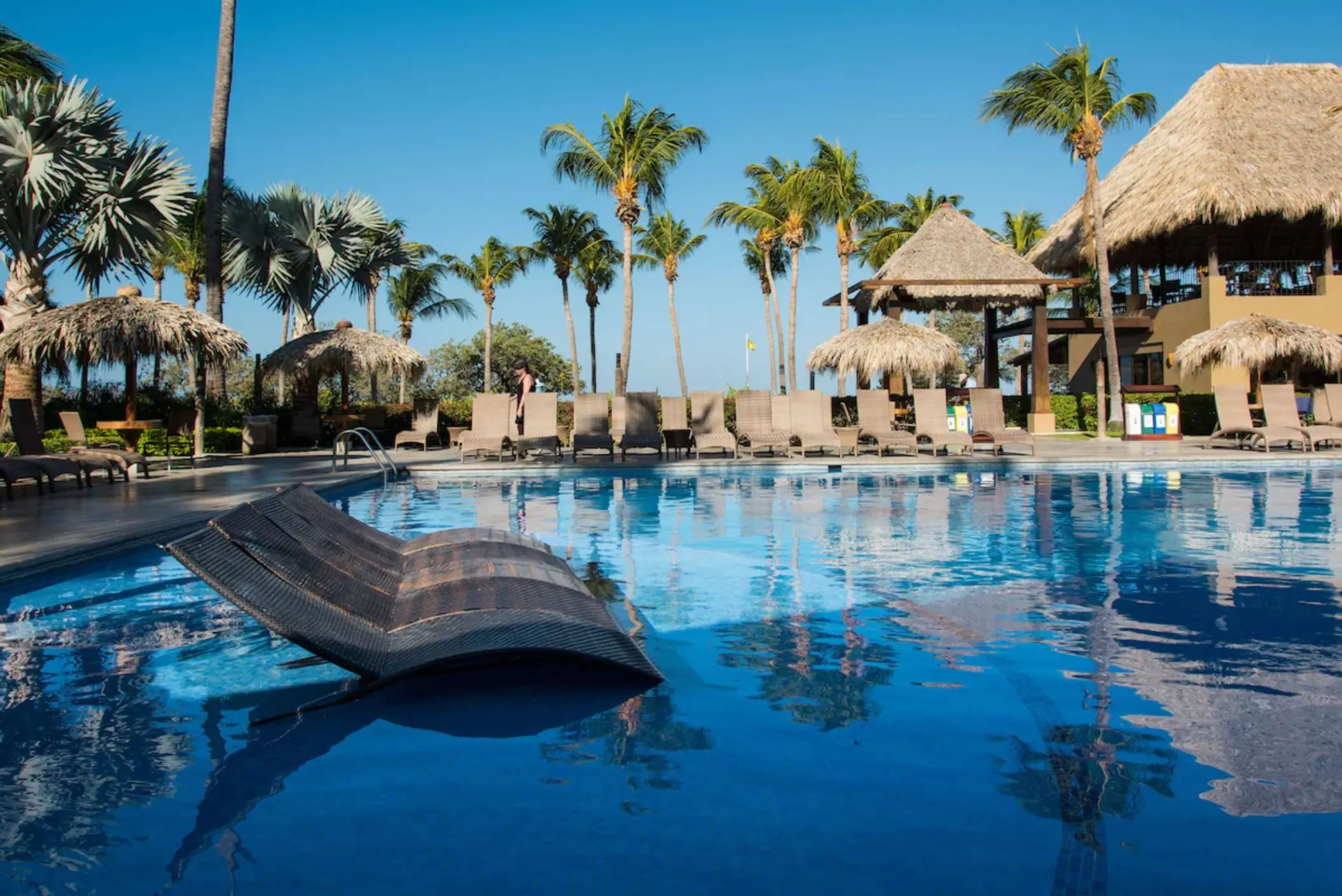 Margaritaville Beach Resort Playa Flamingo pool with in-water loungers and thatched umbrellas, Liberia