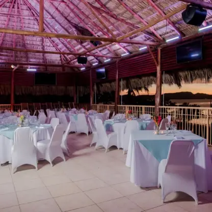Wedding reception setup under a thatched palapa at Margaritaville Playa Flamingo, Liberia