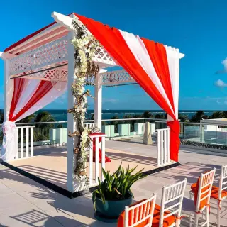Sky Deck wedding ceremony setup with red and white draping at Margaritaville Island Reserve Riviera Cancun