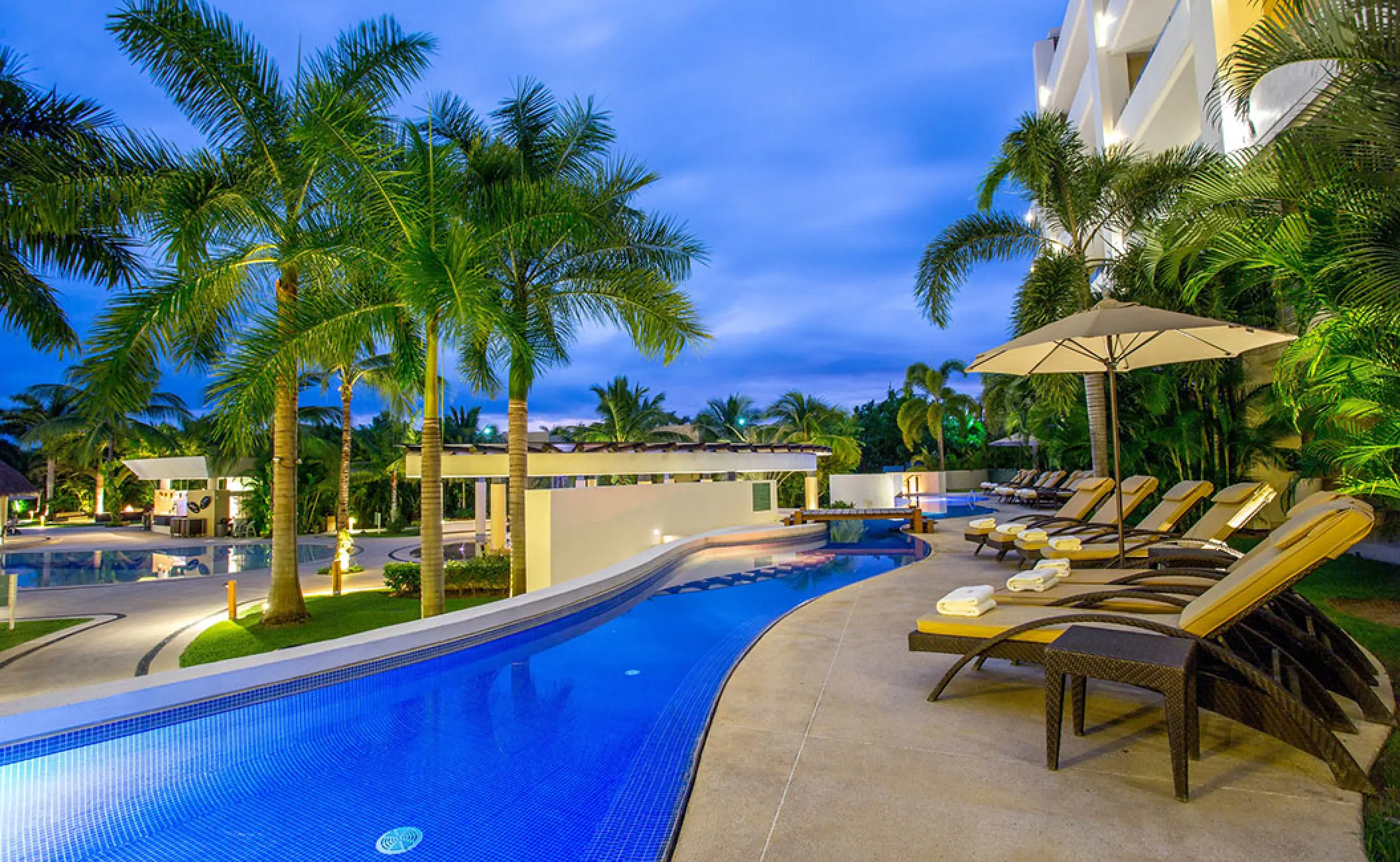 Marival Distinct Residences demi pool and lounge chairs at dusk, Puerto Vallarta