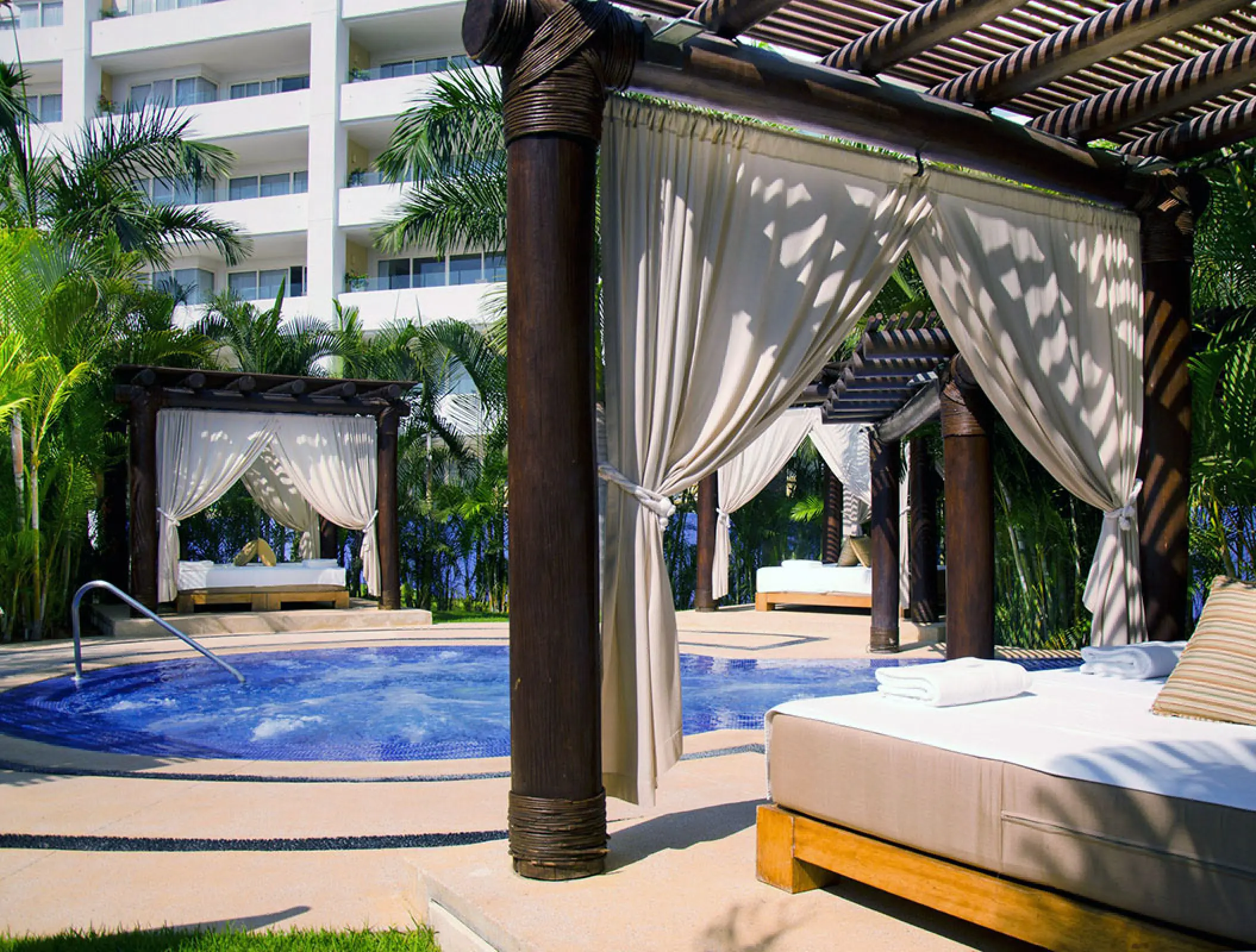 Outdoor jacuzzi and poolside cabanas at Marival Distinct Luxury Residences, Puerto Vallarta