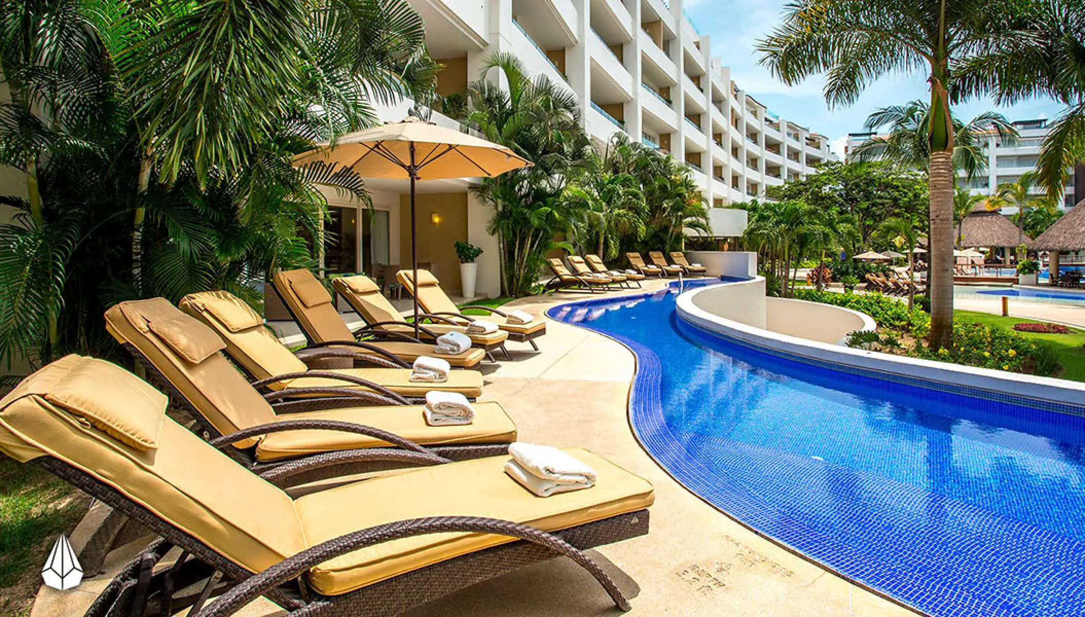 Marival Distinct Residences poolside lounge chairs by a winding blue pool, Puerto Vallarta
