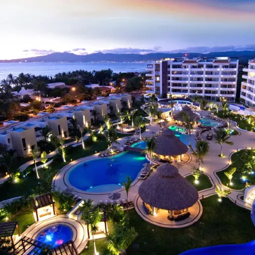 Night view of lit pools and villas at Marival Distinct Luxury Residences, Puerto Vallarta
