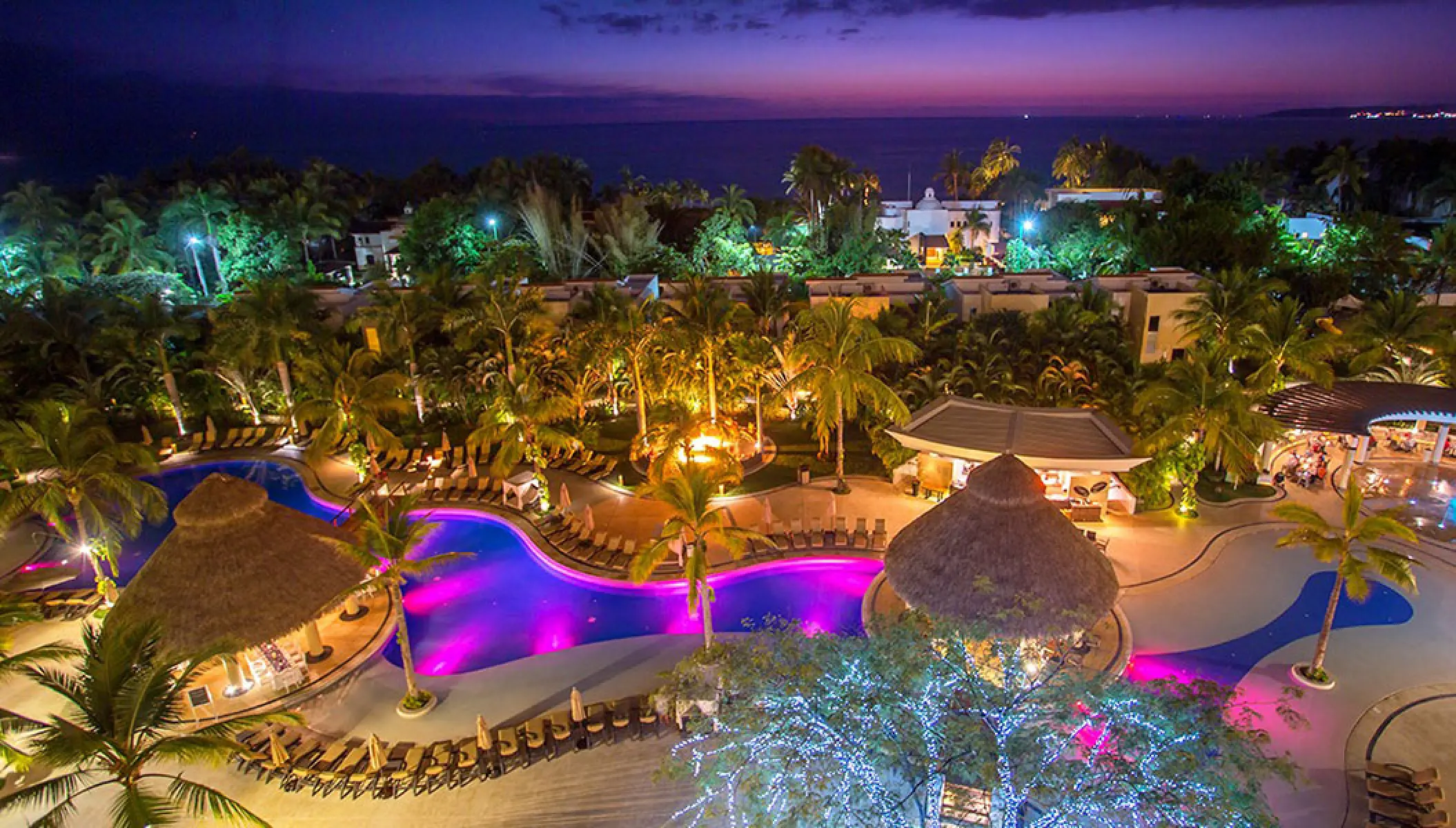 Marival Distinct Residences illuminated pool area and palapa bars at night, Puerto Vallarta