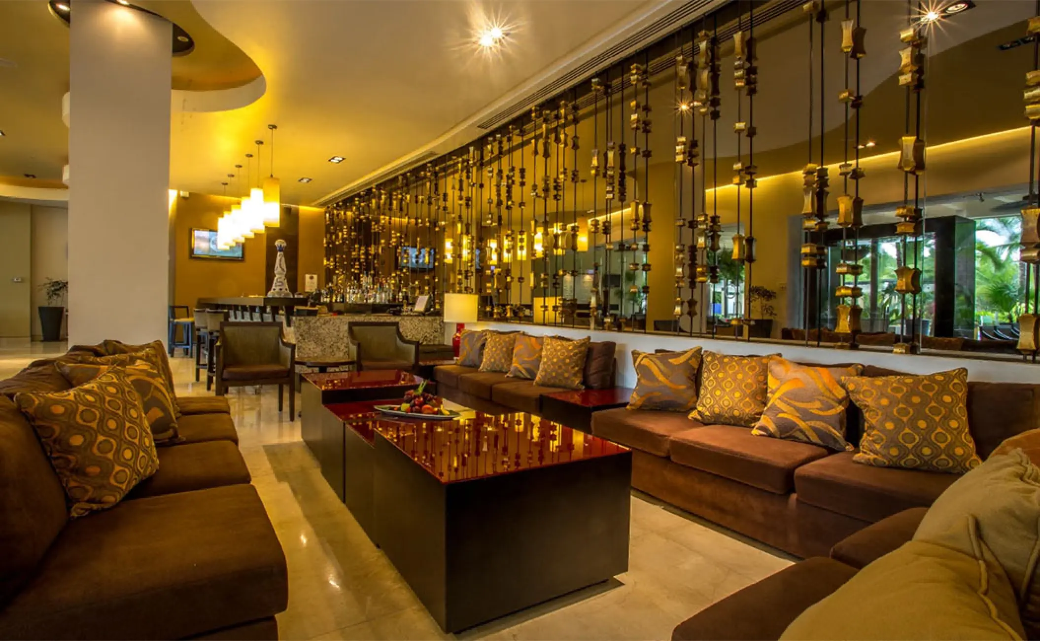 Modern lobby bar lounge with brown sofas and warm lighting at Marival Distinct, Puerto Vallarta