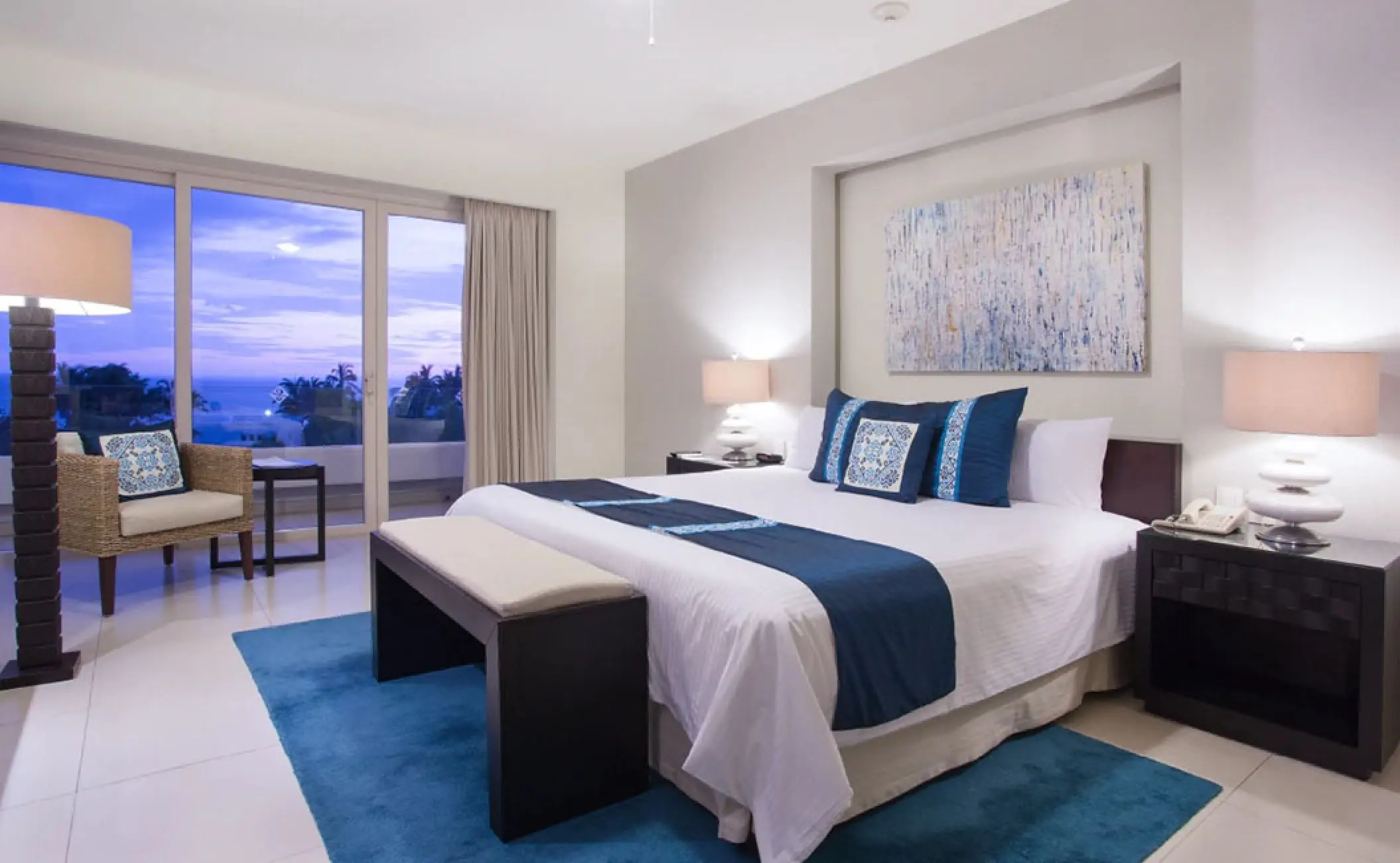 Penthouse suite bedroom with blue accents and ocean views at Marival Distinct, Puerto Vallarta