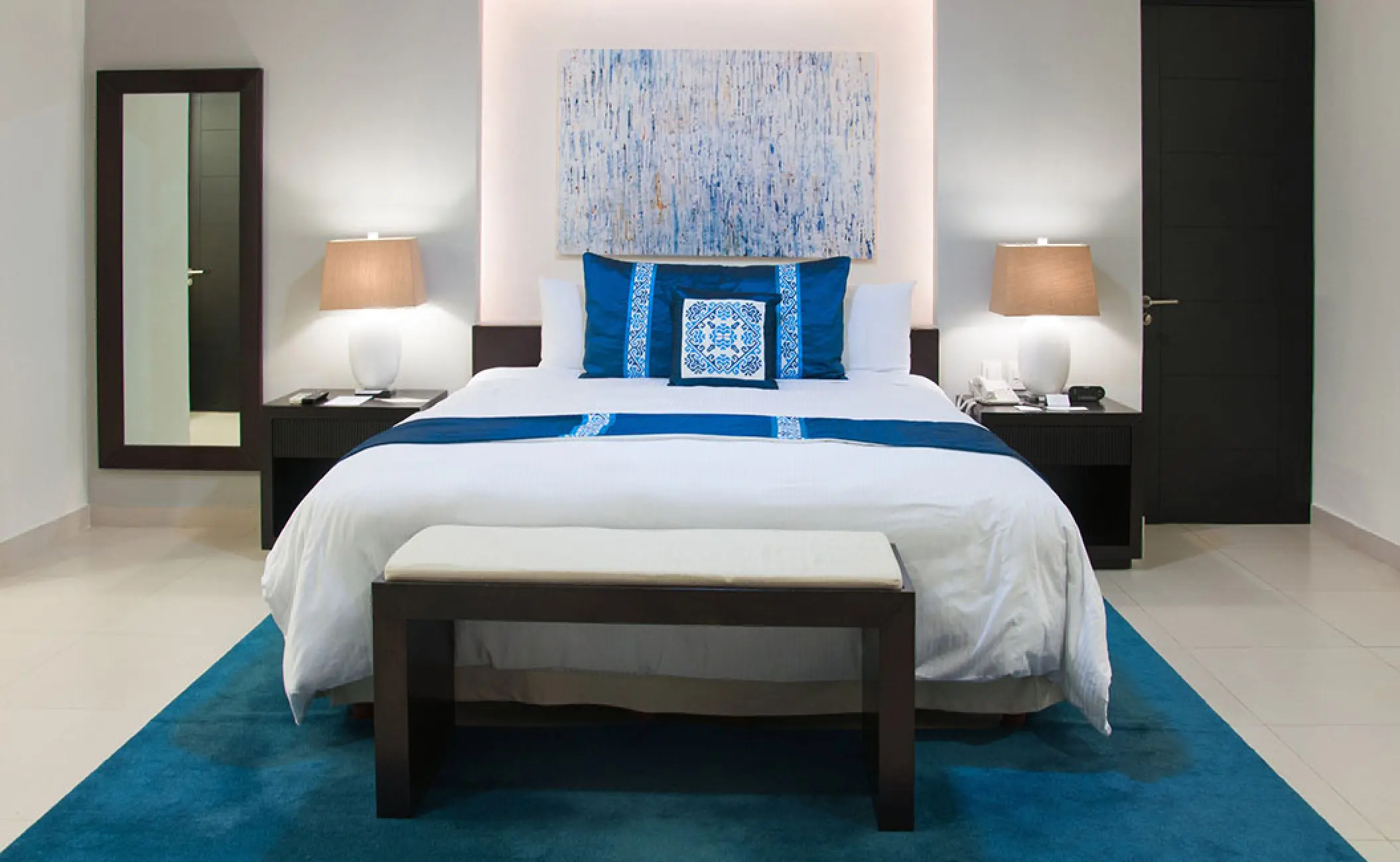Villa bedroom with blue accents and white linens at Marival Distinct, Puerto Vallarta