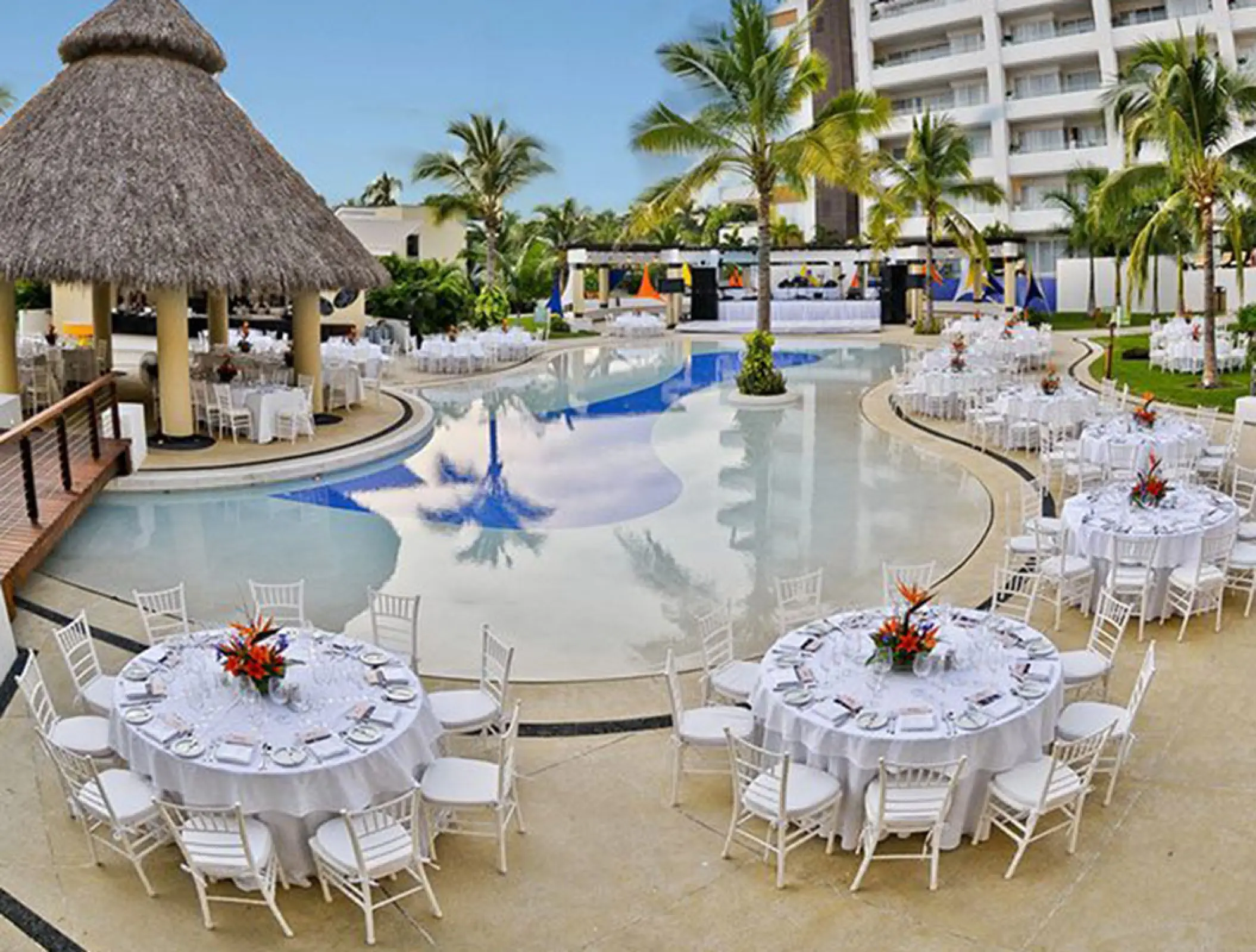 Pool terrace wedding reception setup with white tables at Marival Distinct Luxury, Puerto Vallarta