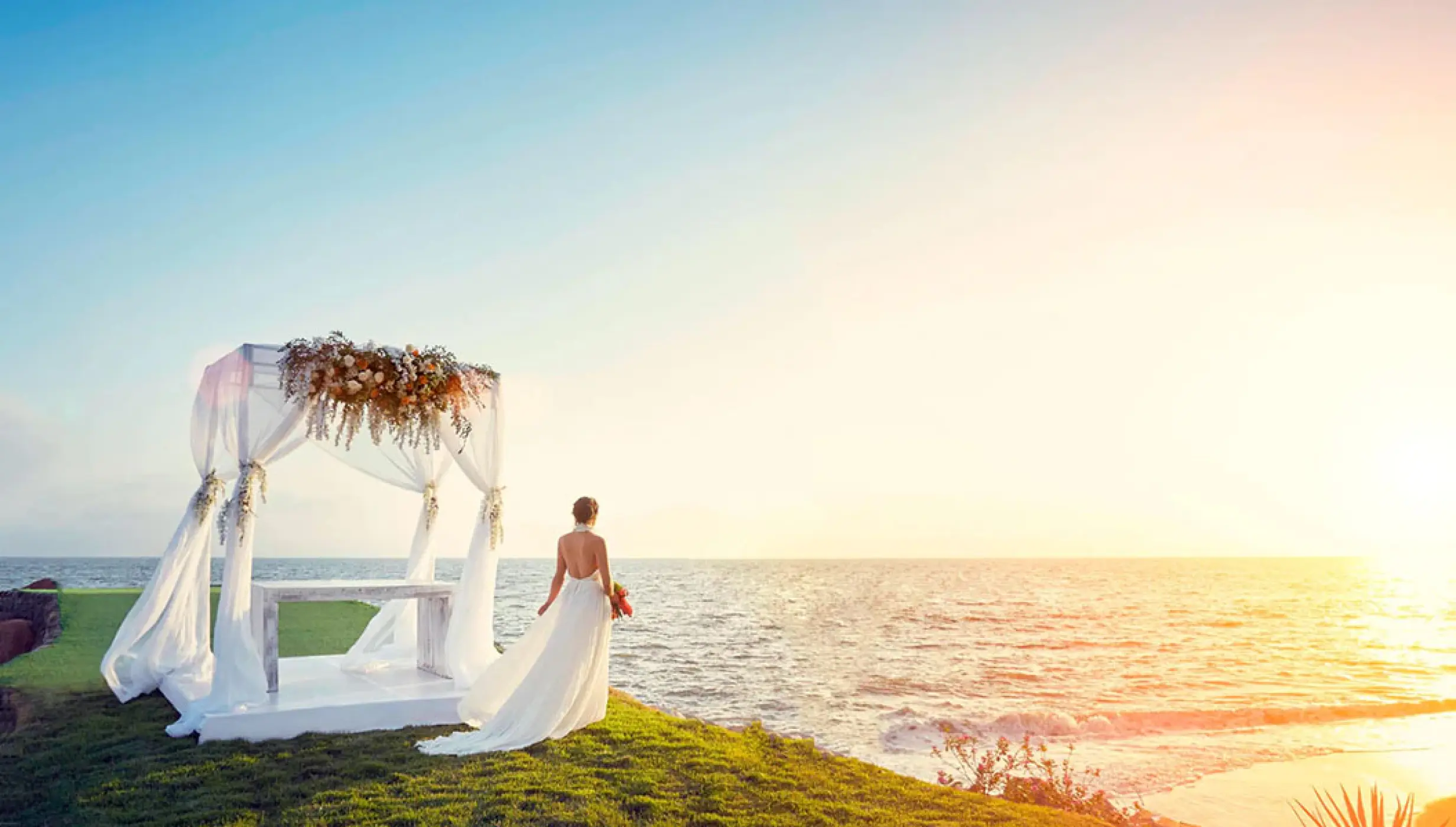 Bride standing by a beachfront wedding gazebo at sunset at Marriott Puerto Vallarta, Puerto Vallarta