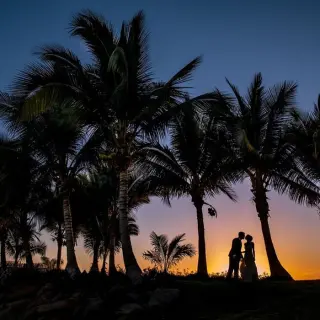 Silhouette of a couple kissing under palm trees at sunset, Marriott Puerto Vallarta
