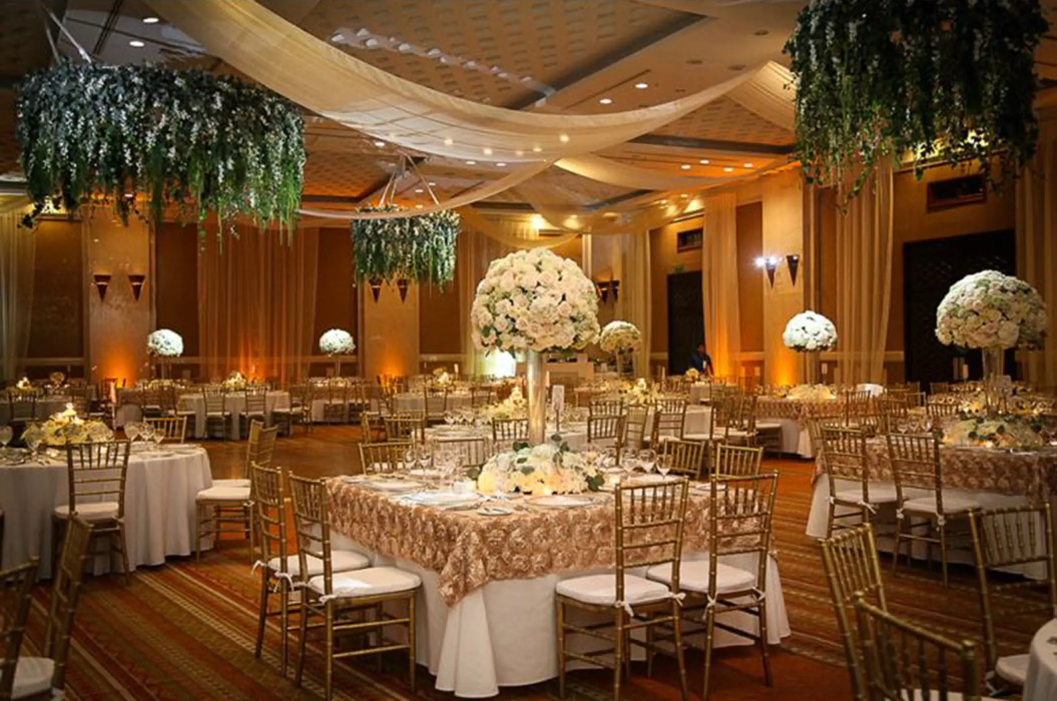 Indoor ballroom wedding reception at Marriott Puerto Vallarta with floral centerpieces and hanging greenery