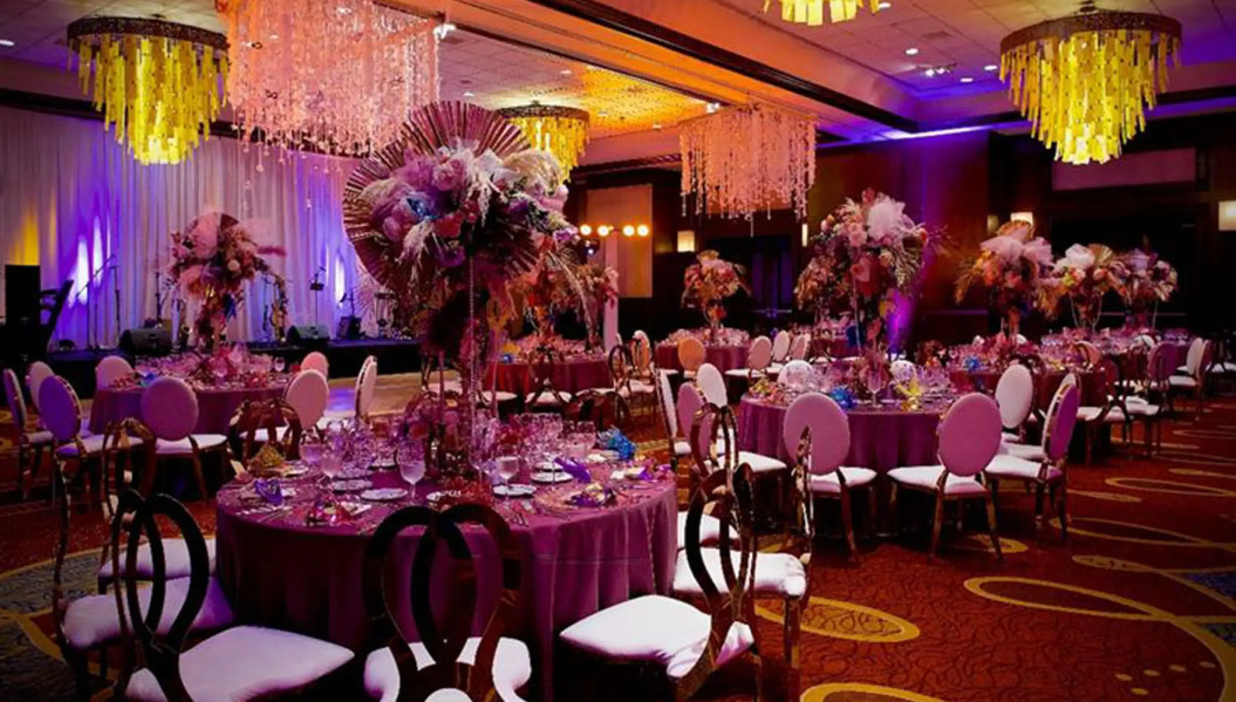 Indoor wedding reception with purple lighting and floral centerpieces at Marriott Puerto Vallarta, Puerto Vallarta