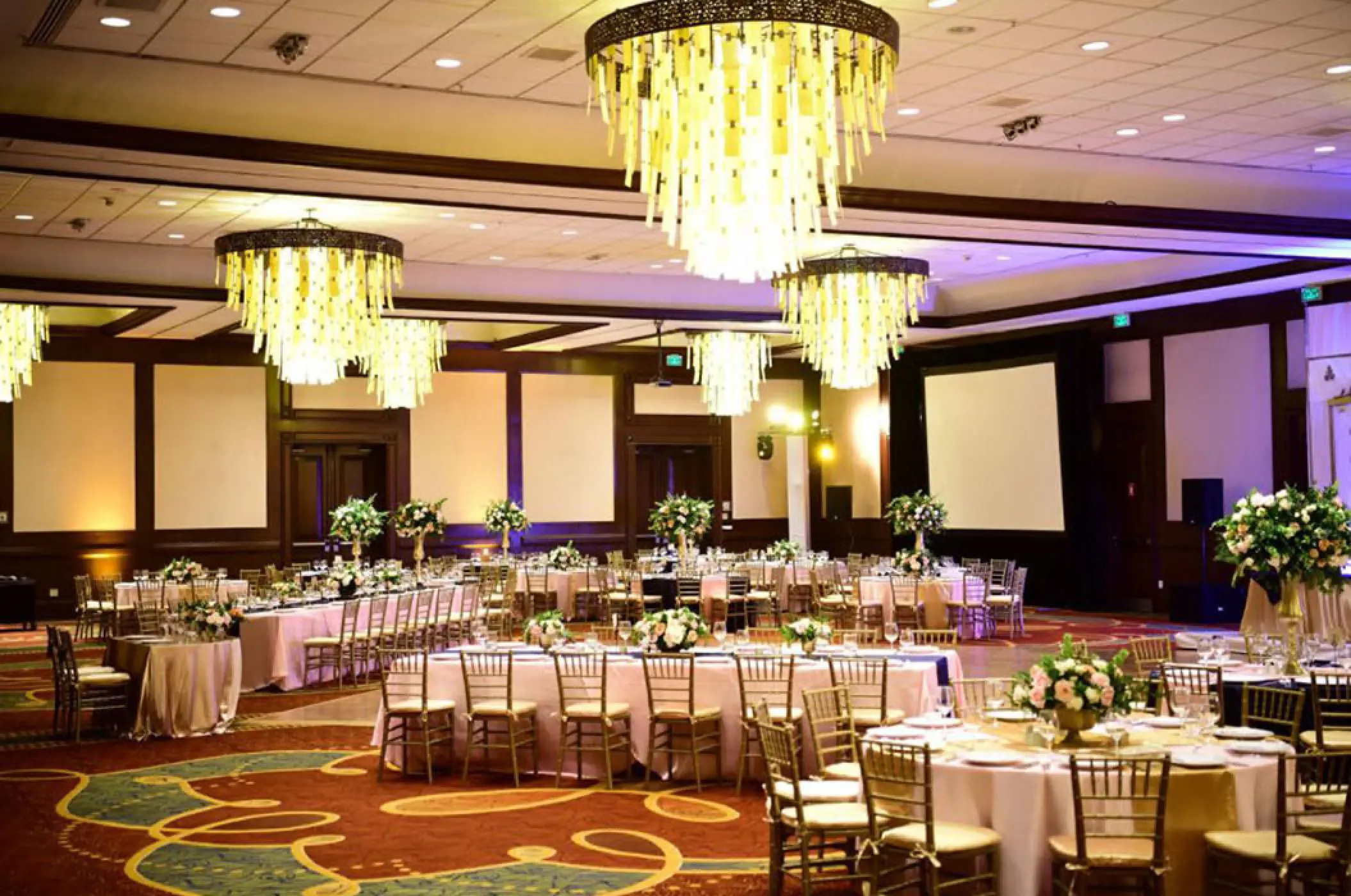 Indoor wedding reception with gold chandeliers and floral centerpieces at Marriott Puerto Vallarta, Puerto Vallarta